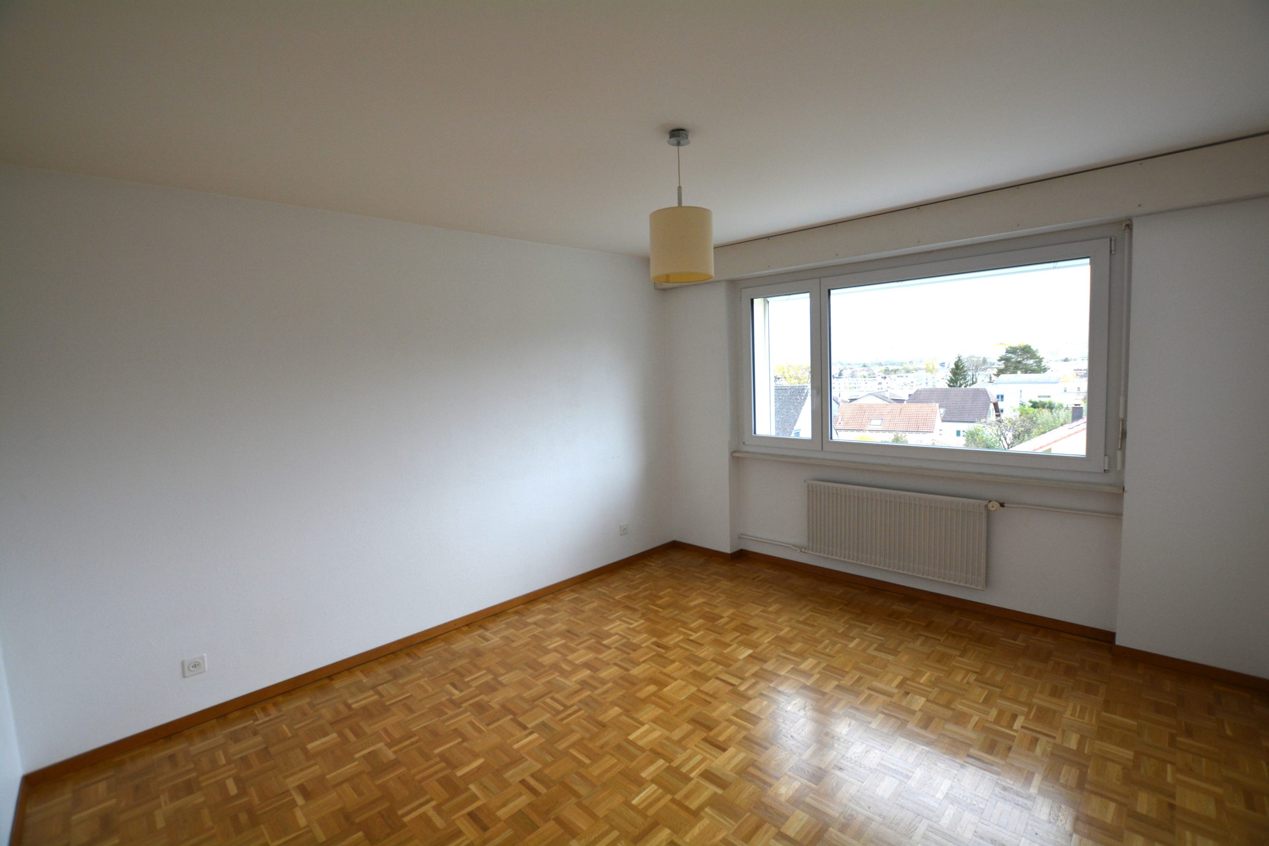 Leeres Zimmer mit Fenster und Parkettboden