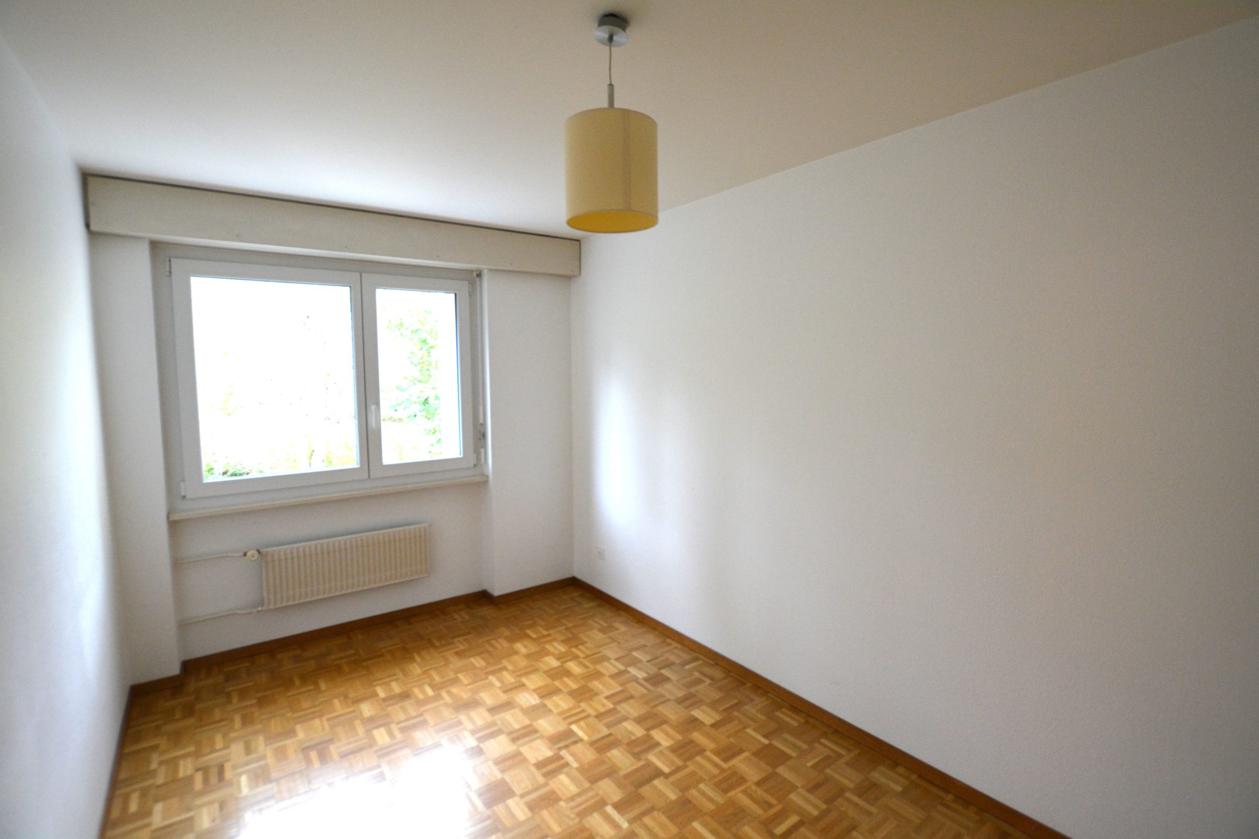 Leerer Wohnraum mit Fenster und Heizkörper
