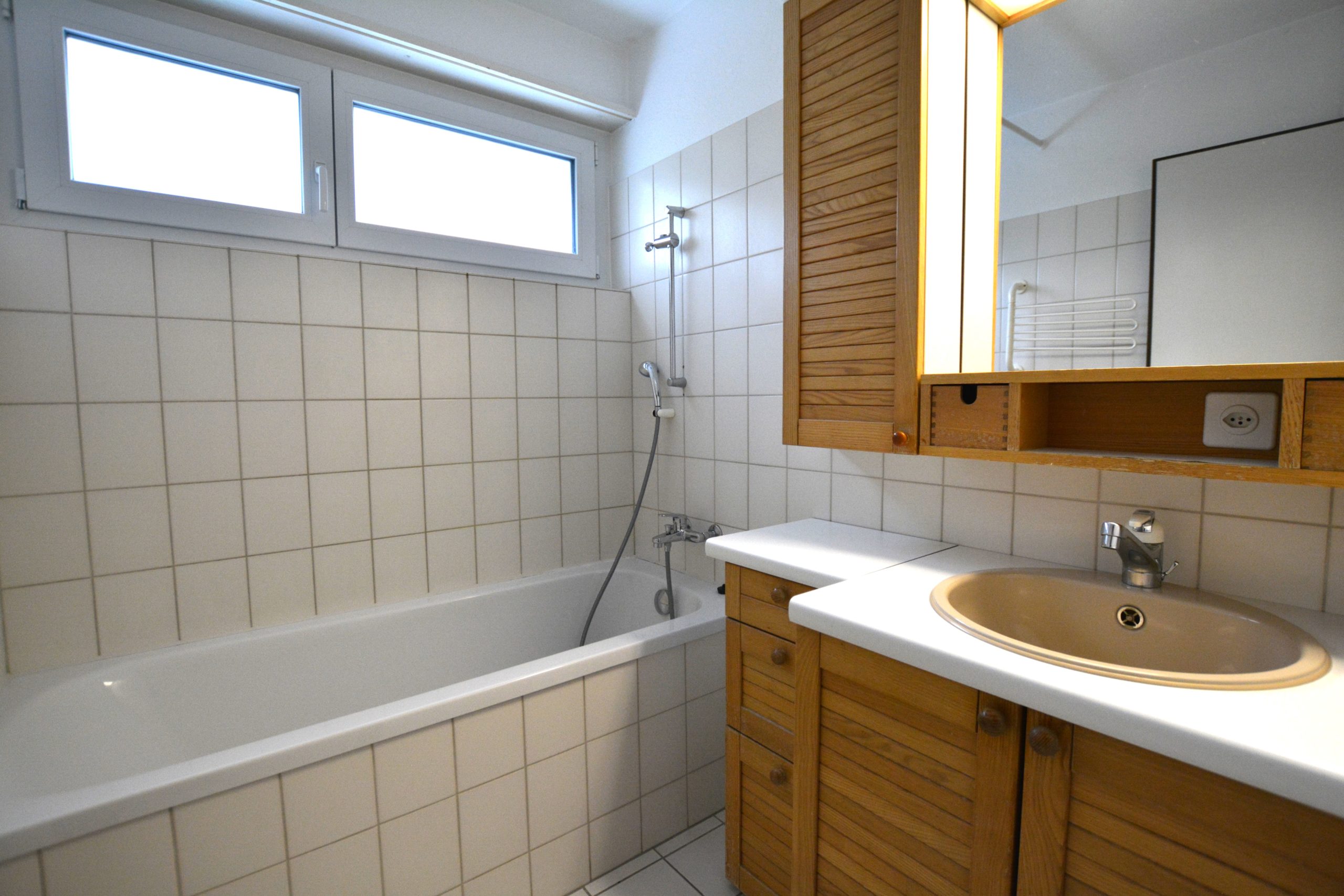 Badezimmer mit Wanne und Holzwaschtisch