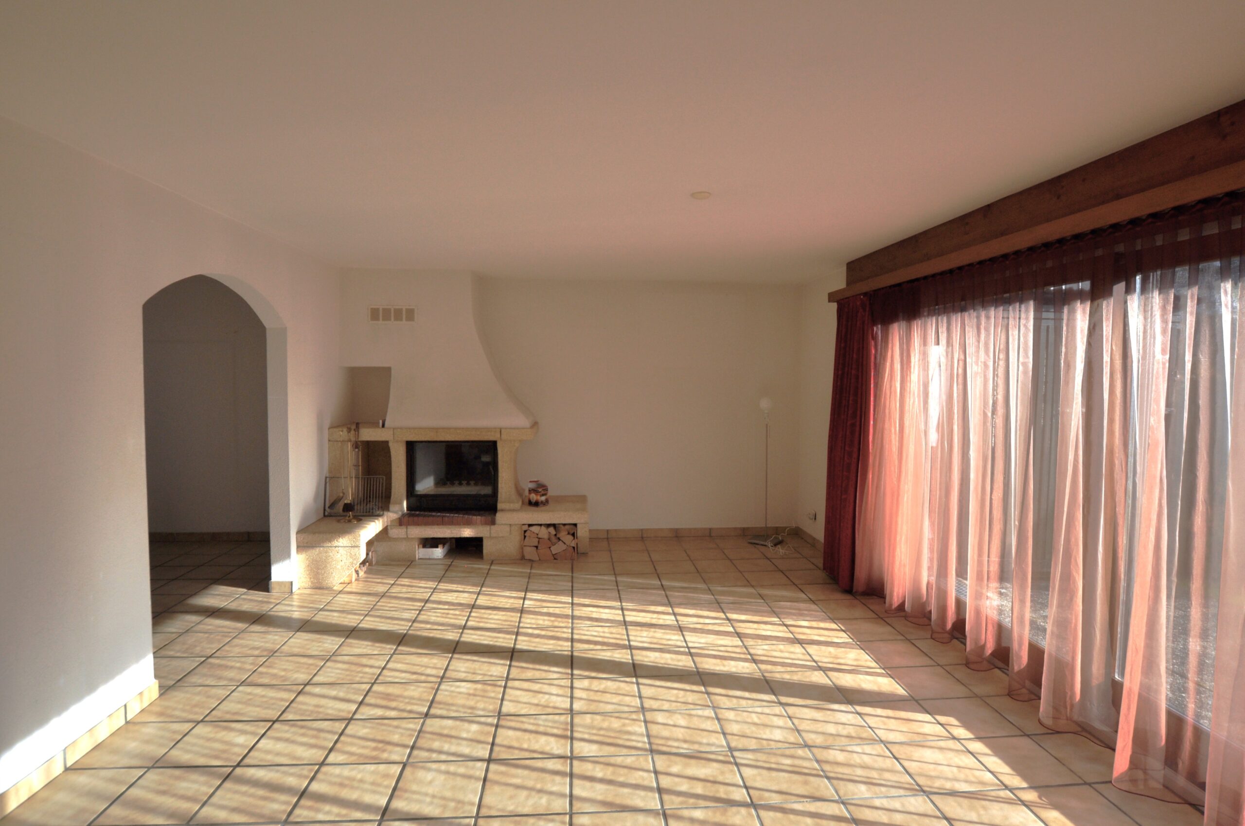 Wohnzimmer mit Kamin und Terrassentüren