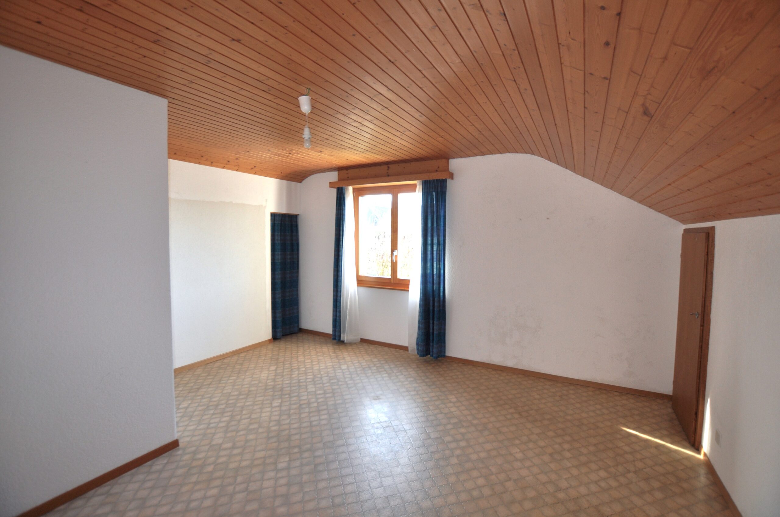 Leerer Dachgeschossraum mit Holzdecke