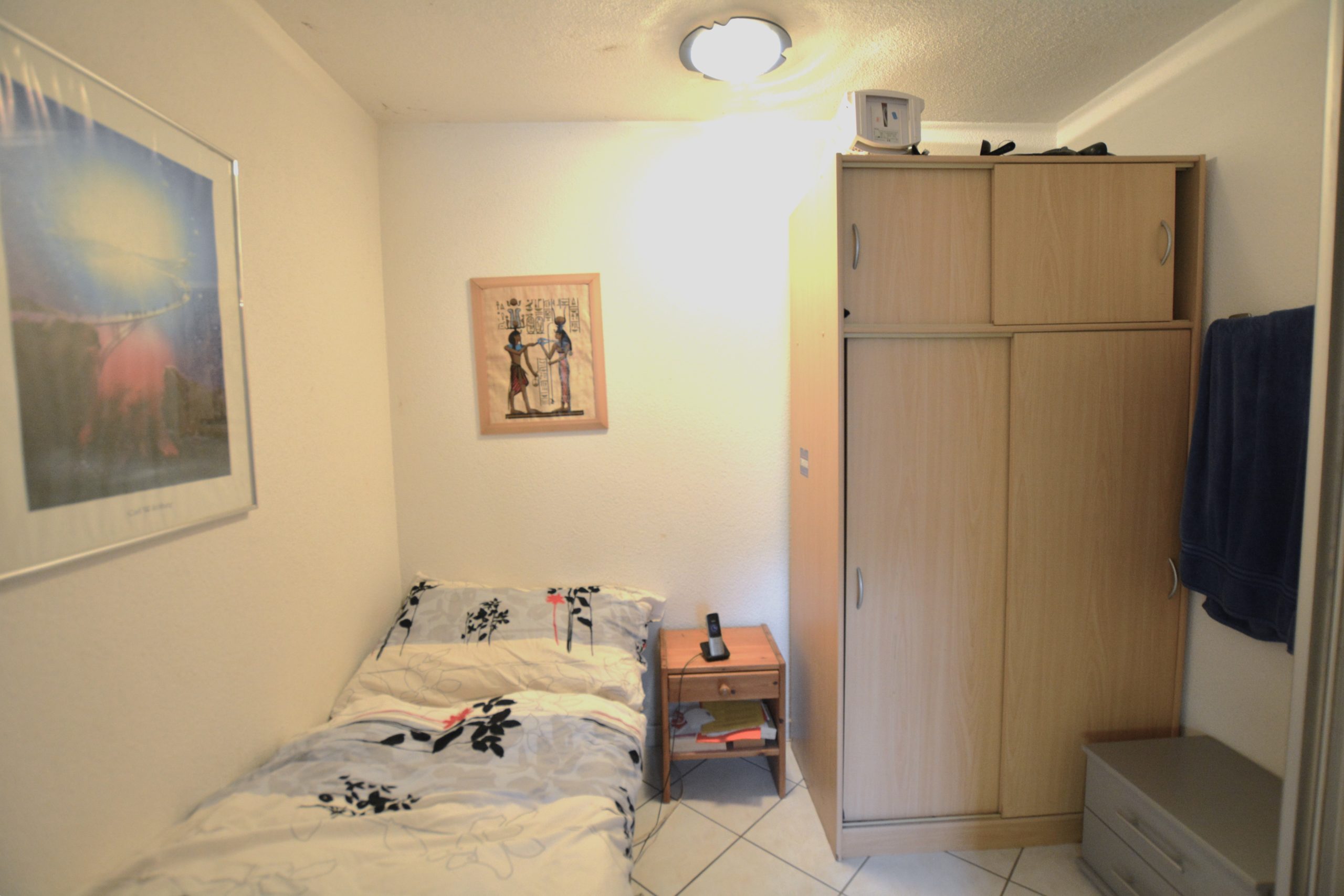 Kleines Schlafzimmer mit Einzelbett und Kleiderschrank