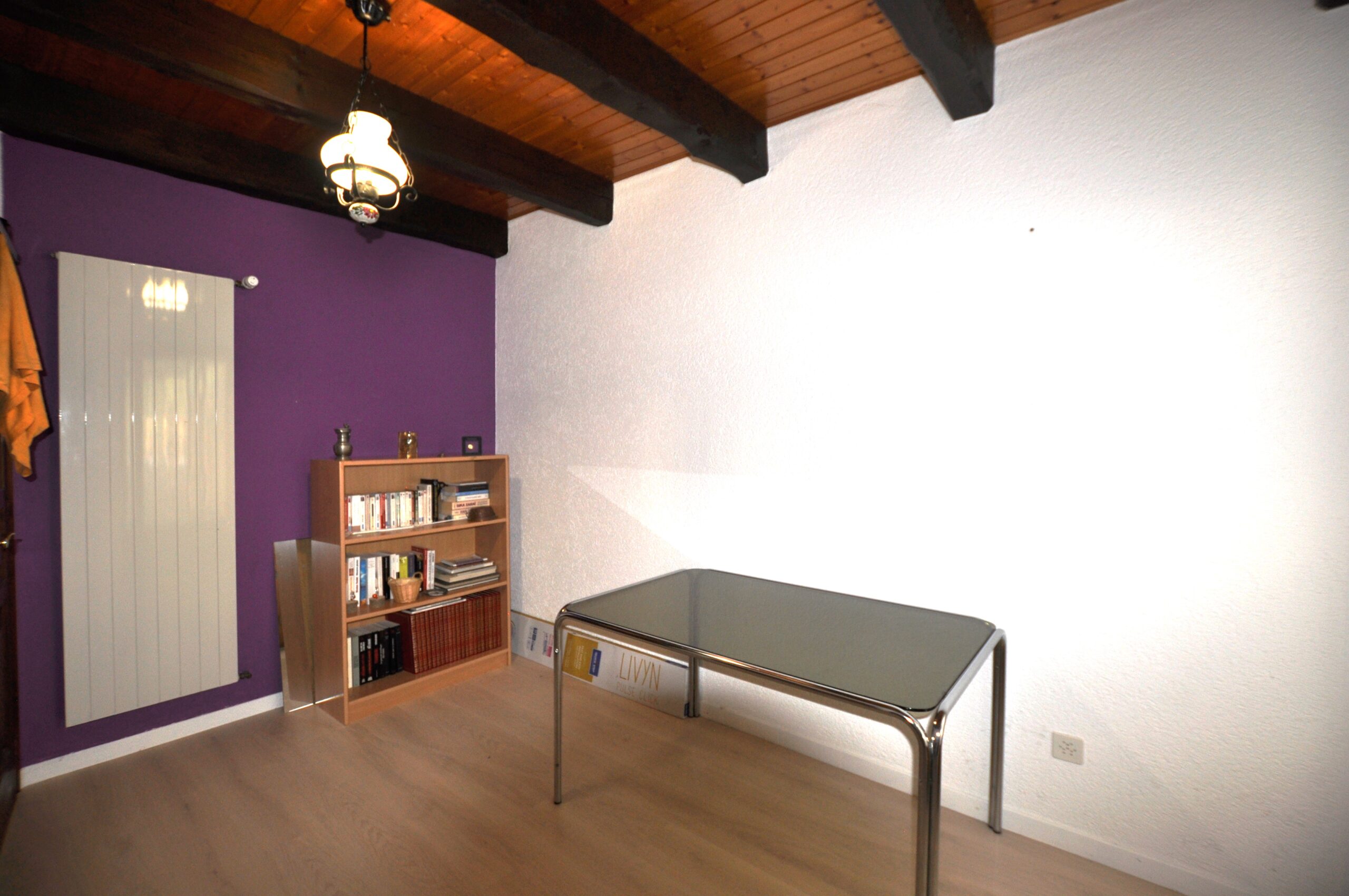 Kleiner Raum mit Holzdecke und farbiger Akzentwand