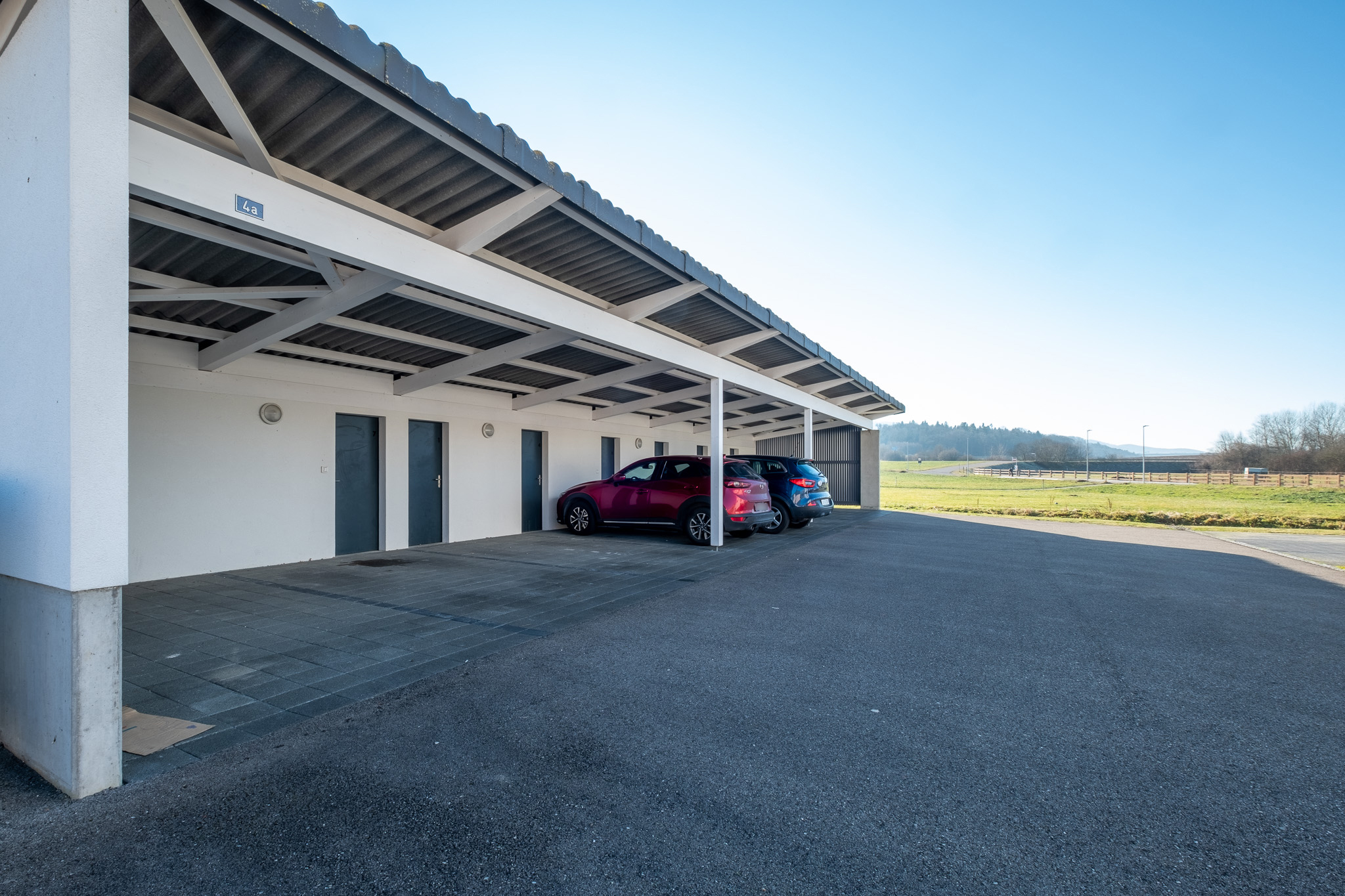 Überdachter Außenstellplatz mit Fahrzeugen