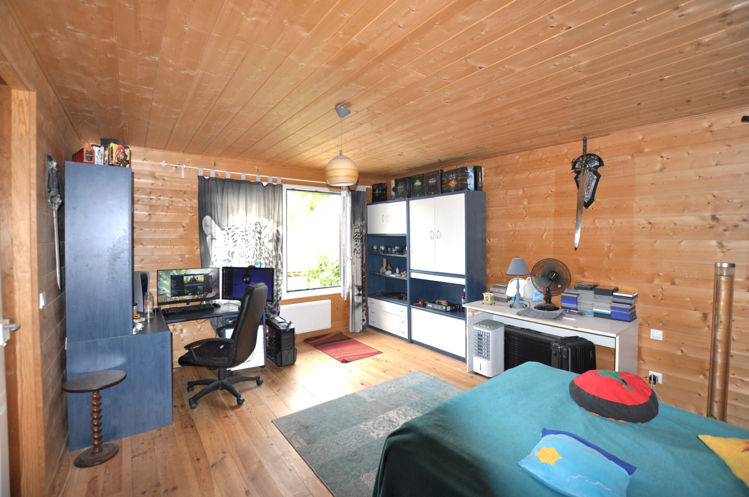 Gemütliches, holzverkleidetes Schlafzimmer mit Arbeitsbereich
