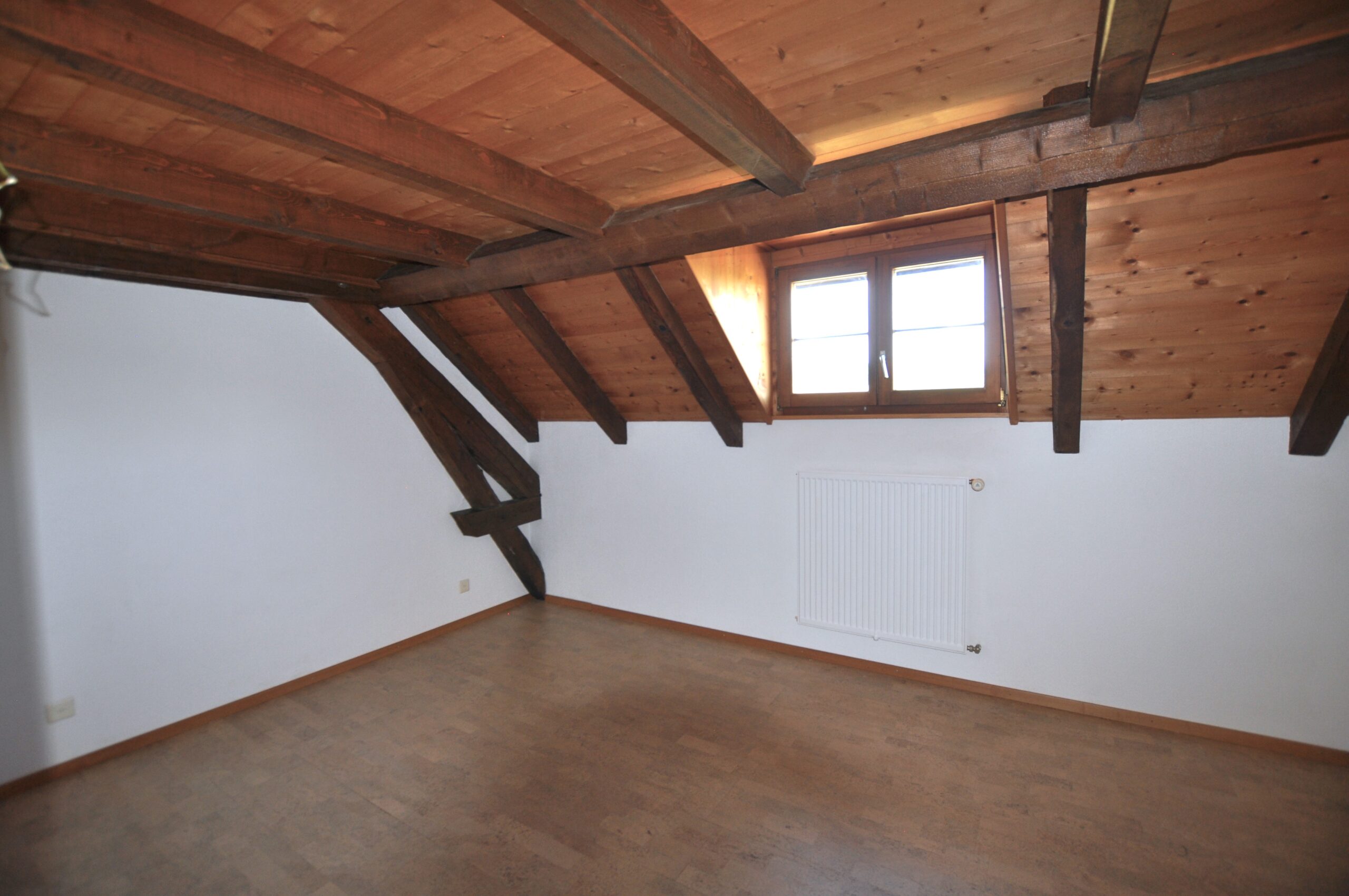 Leerer Dachraum mit sichtbaren Holzbalken