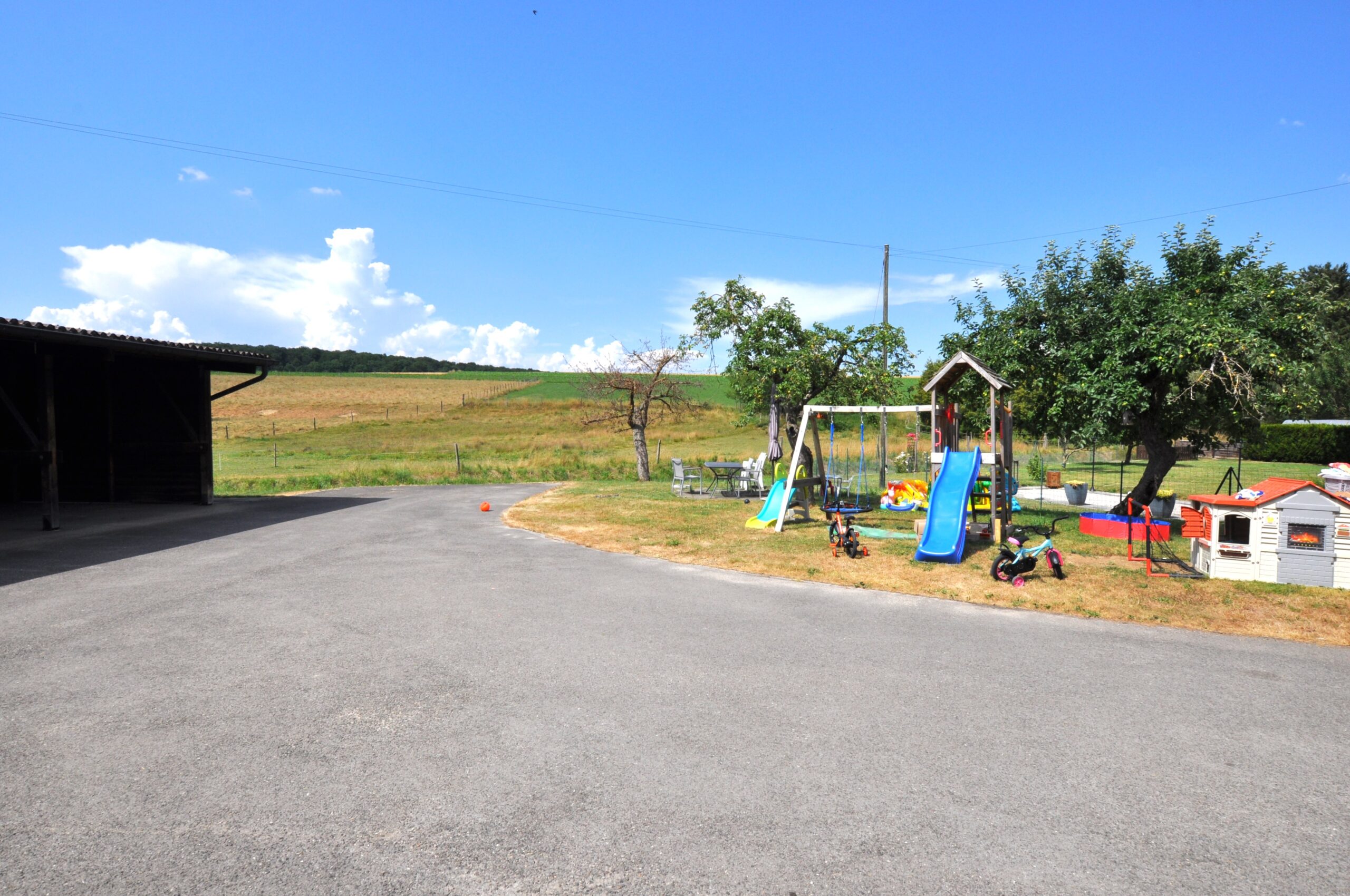 Ländlicher Außenbereich mit Spielplatz und Hofzufahrt