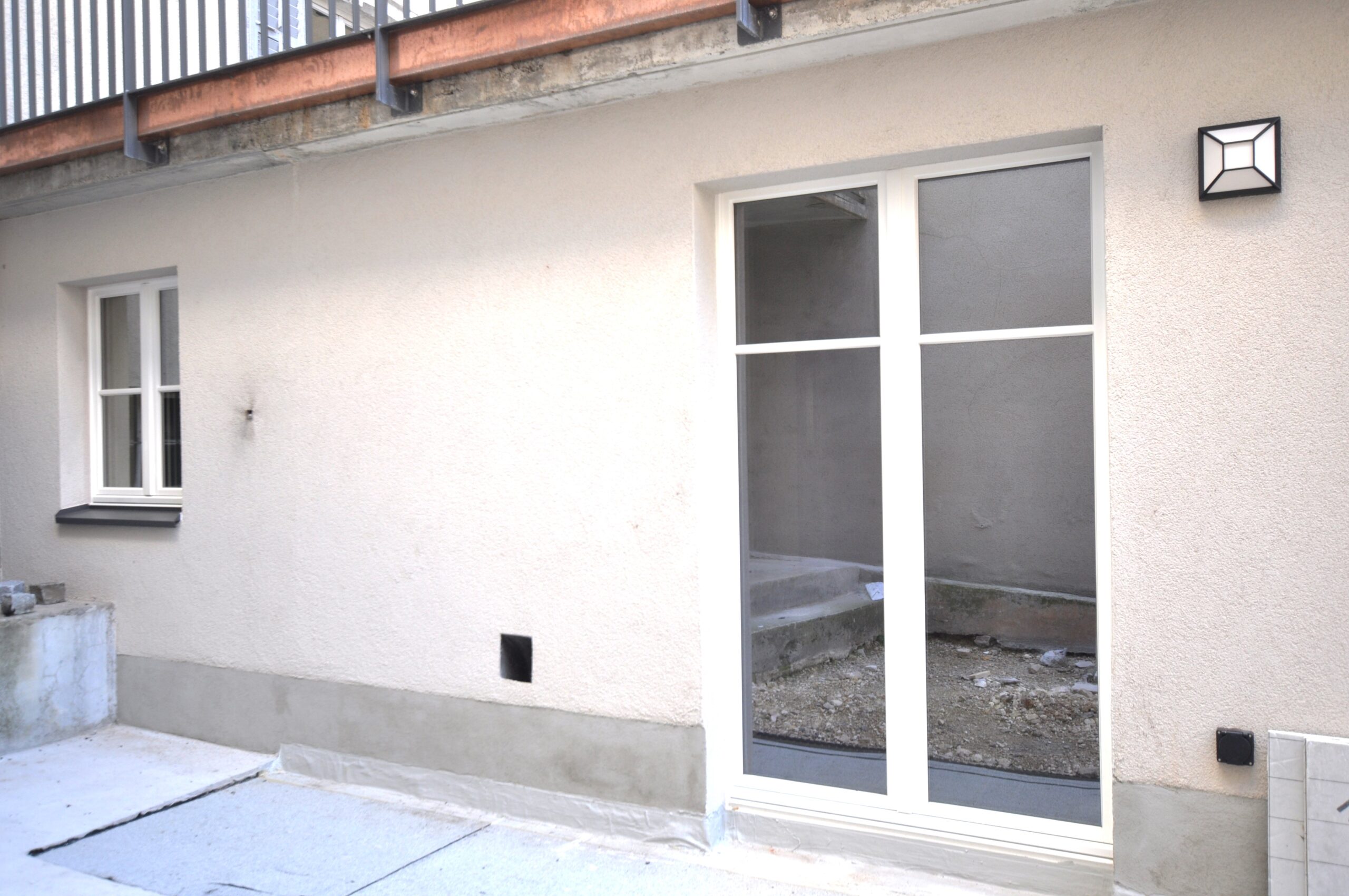 Innenhof mit Glas-Schiebetür und Fassadenansicht
