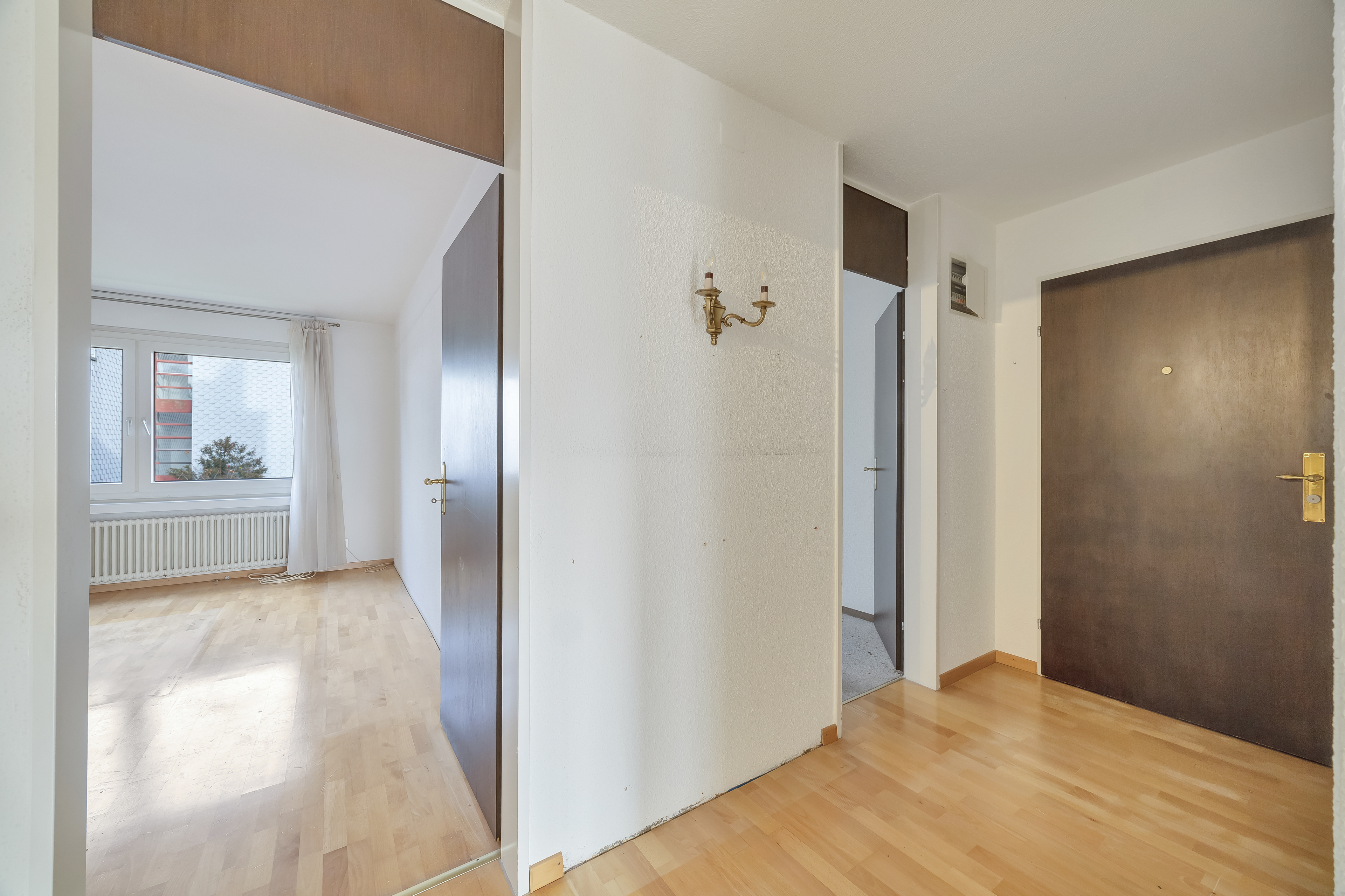 Heller Wohnungsflur mit Blick in ein Zimmer