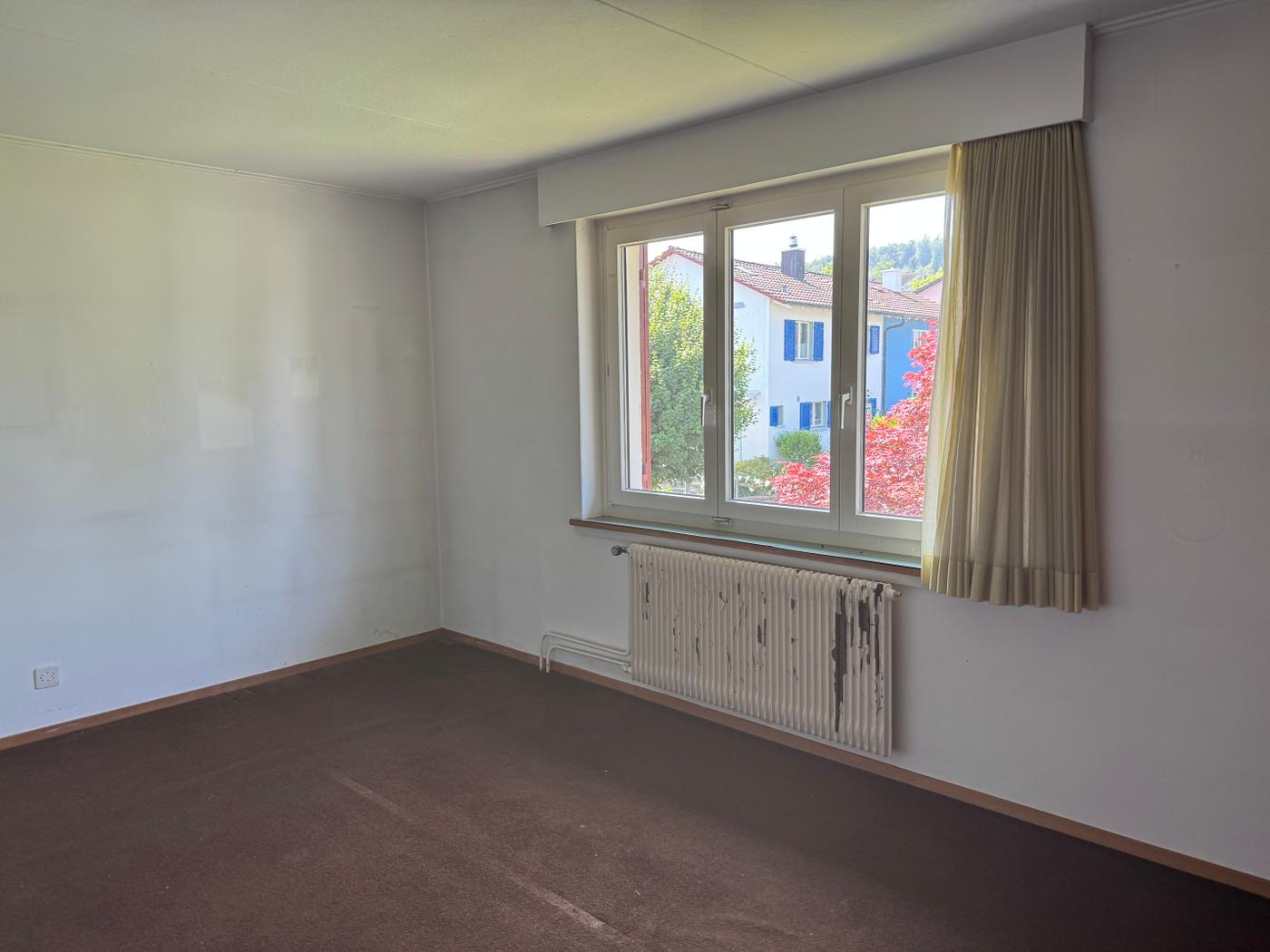 Leeres Zimmer mit Fenster und Heizkörper