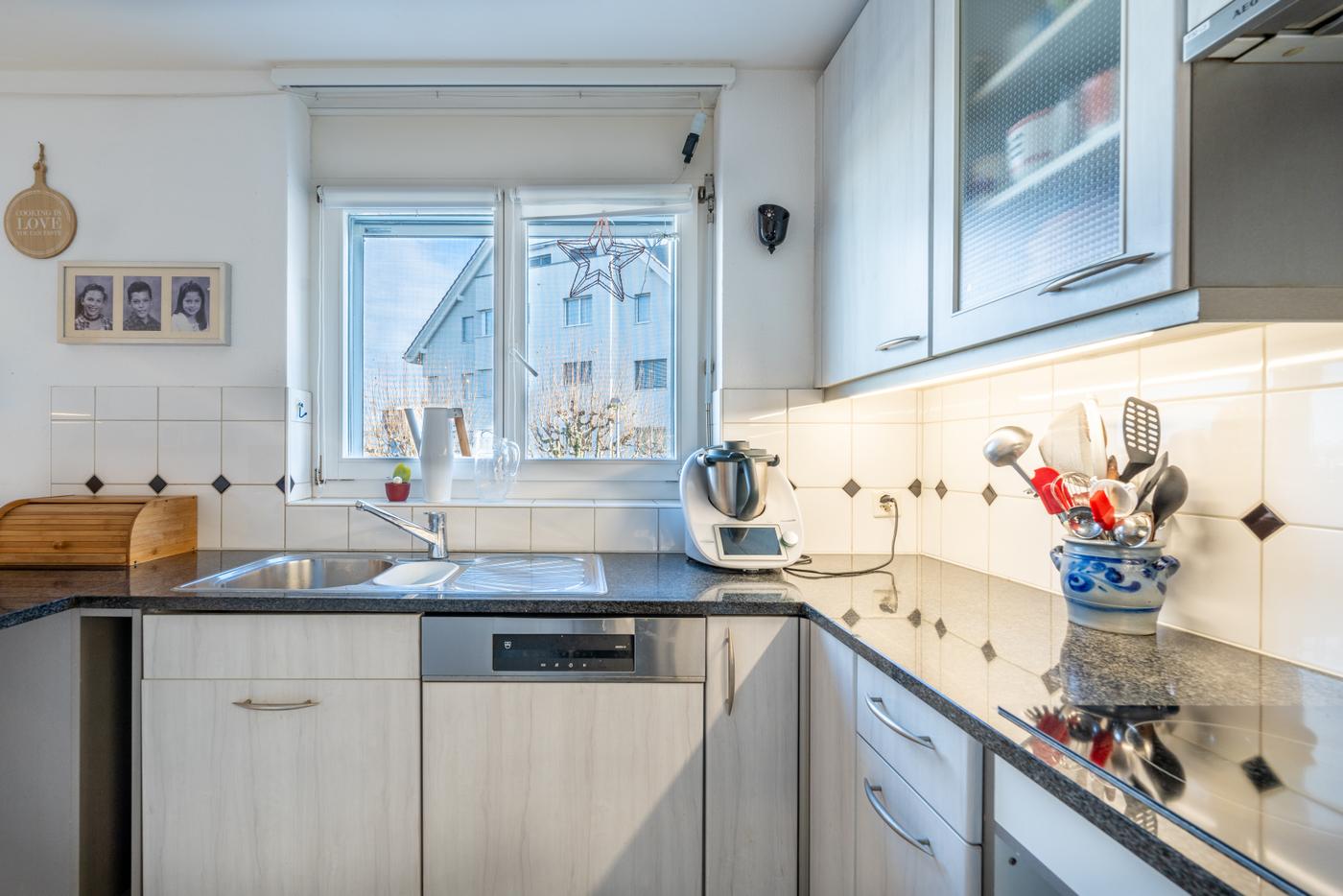 Helle Einbauküche mit Fenster