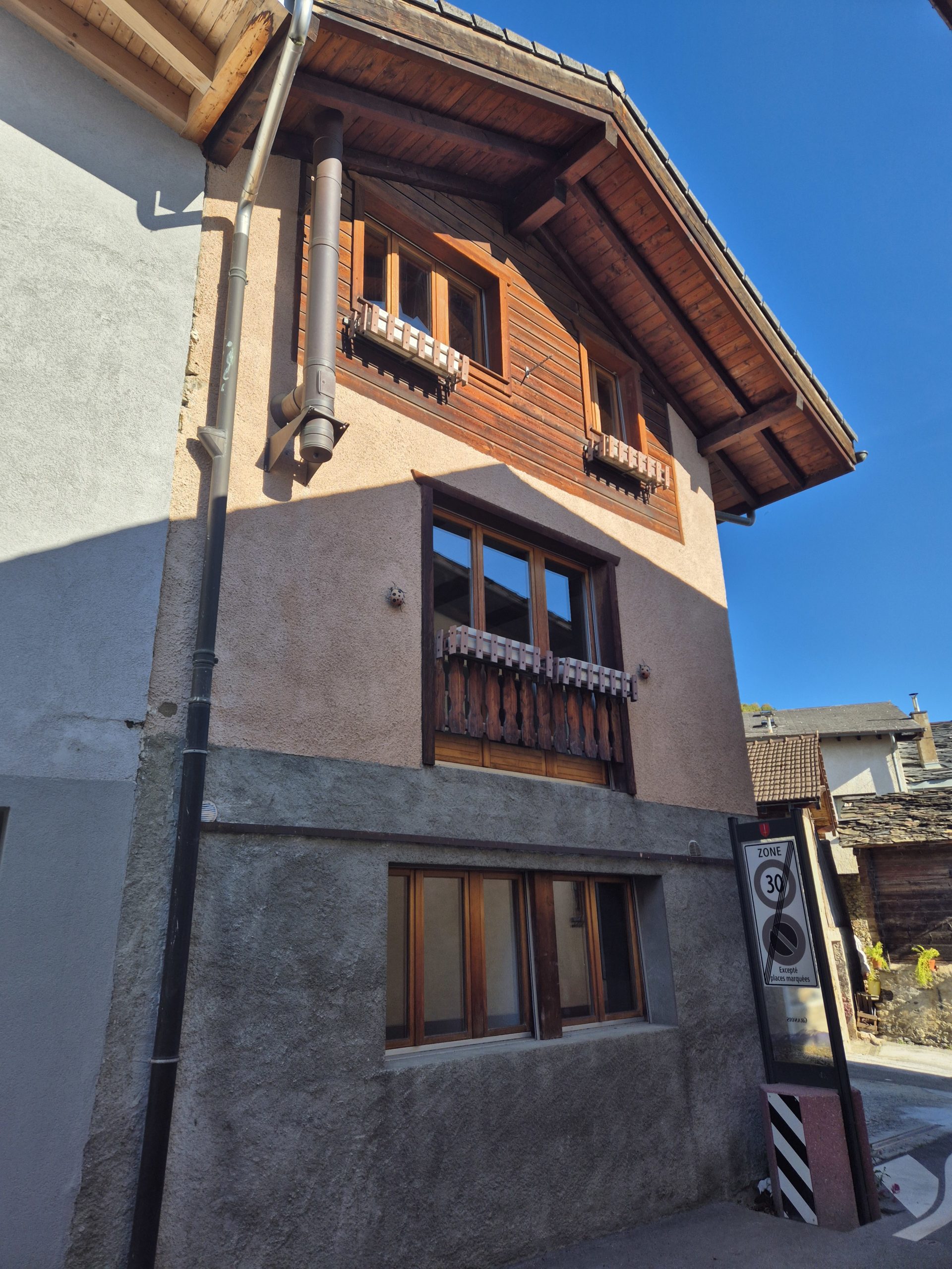Alpine Hausfassade von der Straße aus