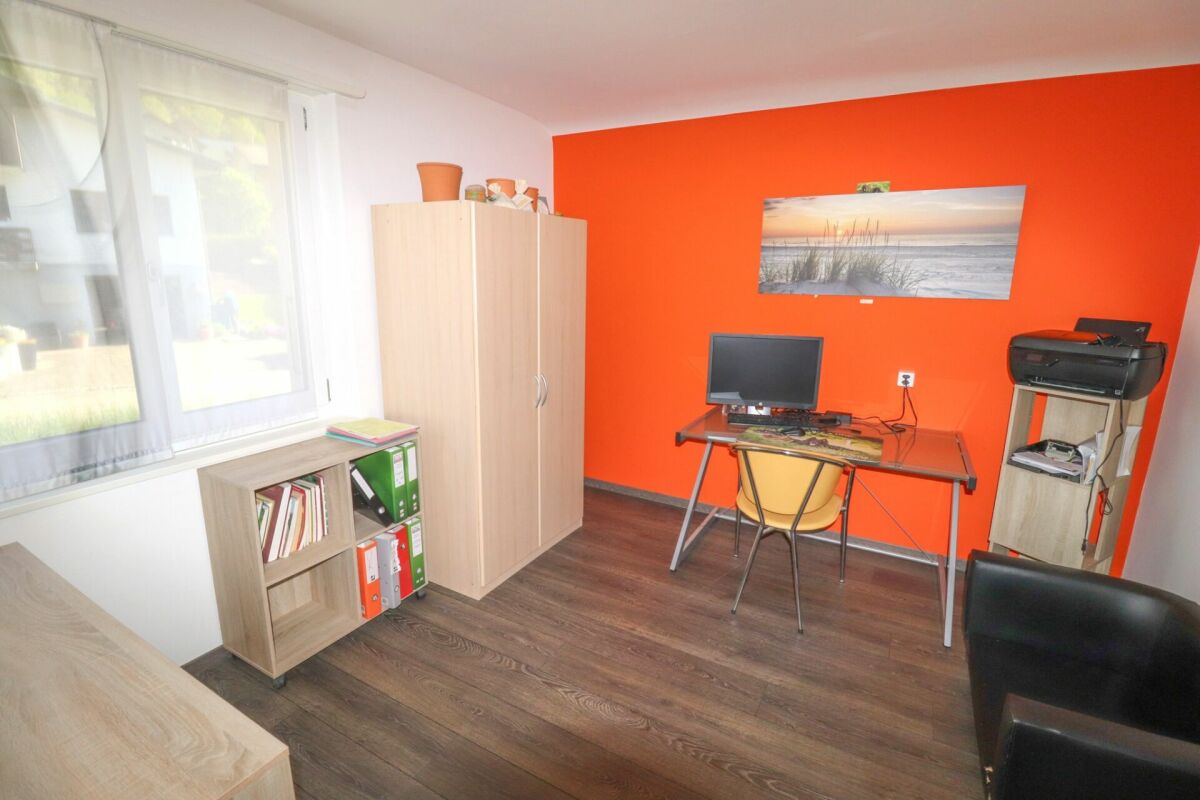 Arbeitszimmer mit orangefarbener Akzentwand