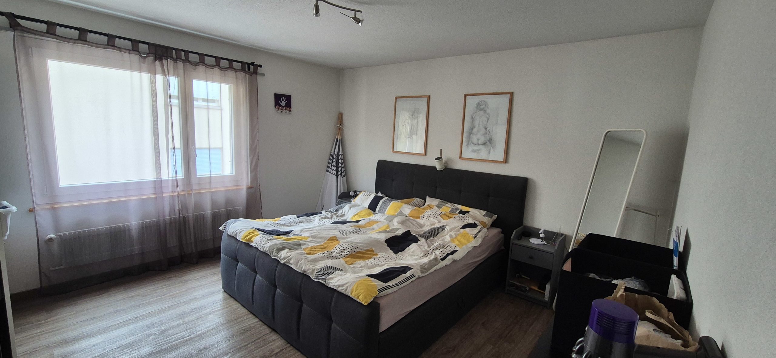 Schlafzimmer mit großem Fenster und Doppelbett