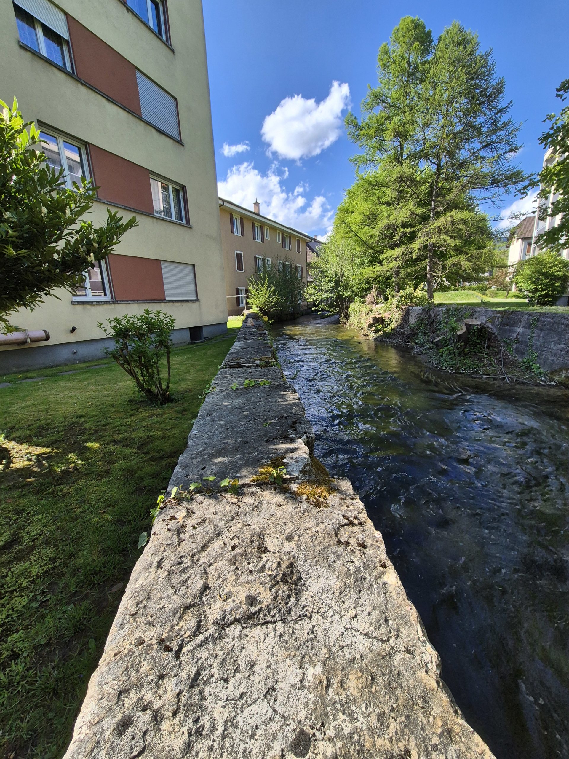 Außenansicht eines Wohngebäudes am Wasserlauf