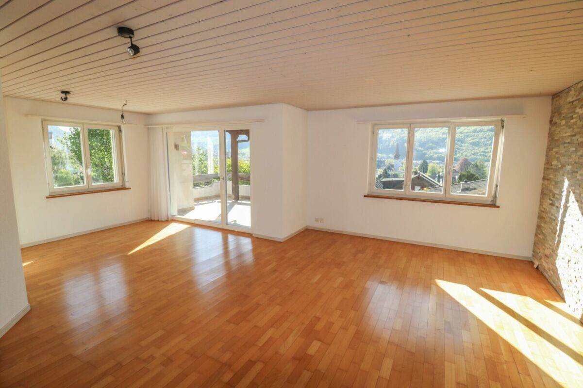 Heller leerer Wohnraum mit Balkon und Bergblick