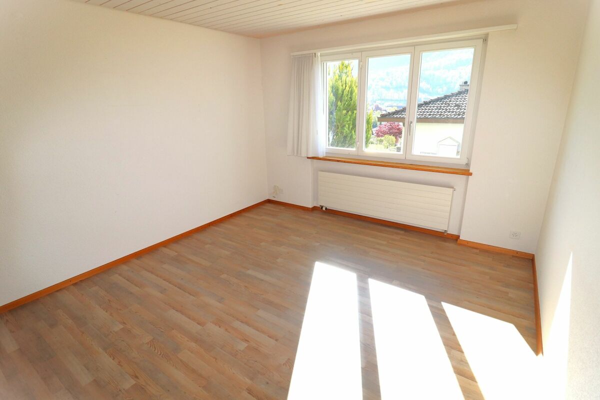 Heller leerer Raum mit Fenster und Laminatboden