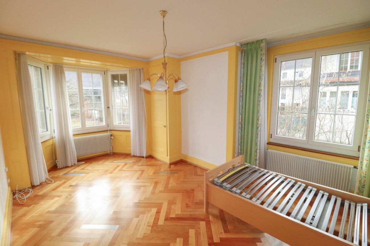 Helles, leeres Schlafzimmer mit Erkerfenstern