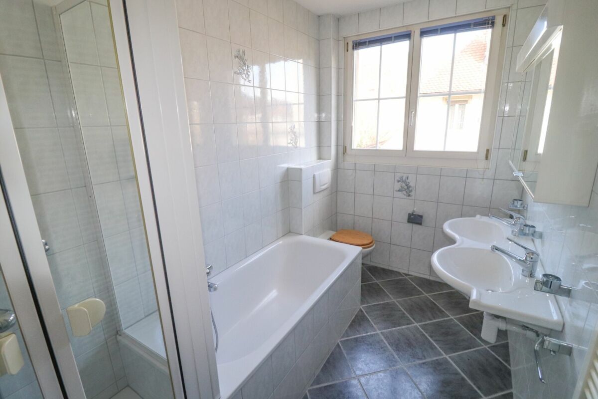 Badezimmer mit Badewanne und Doppelwaschtisch
