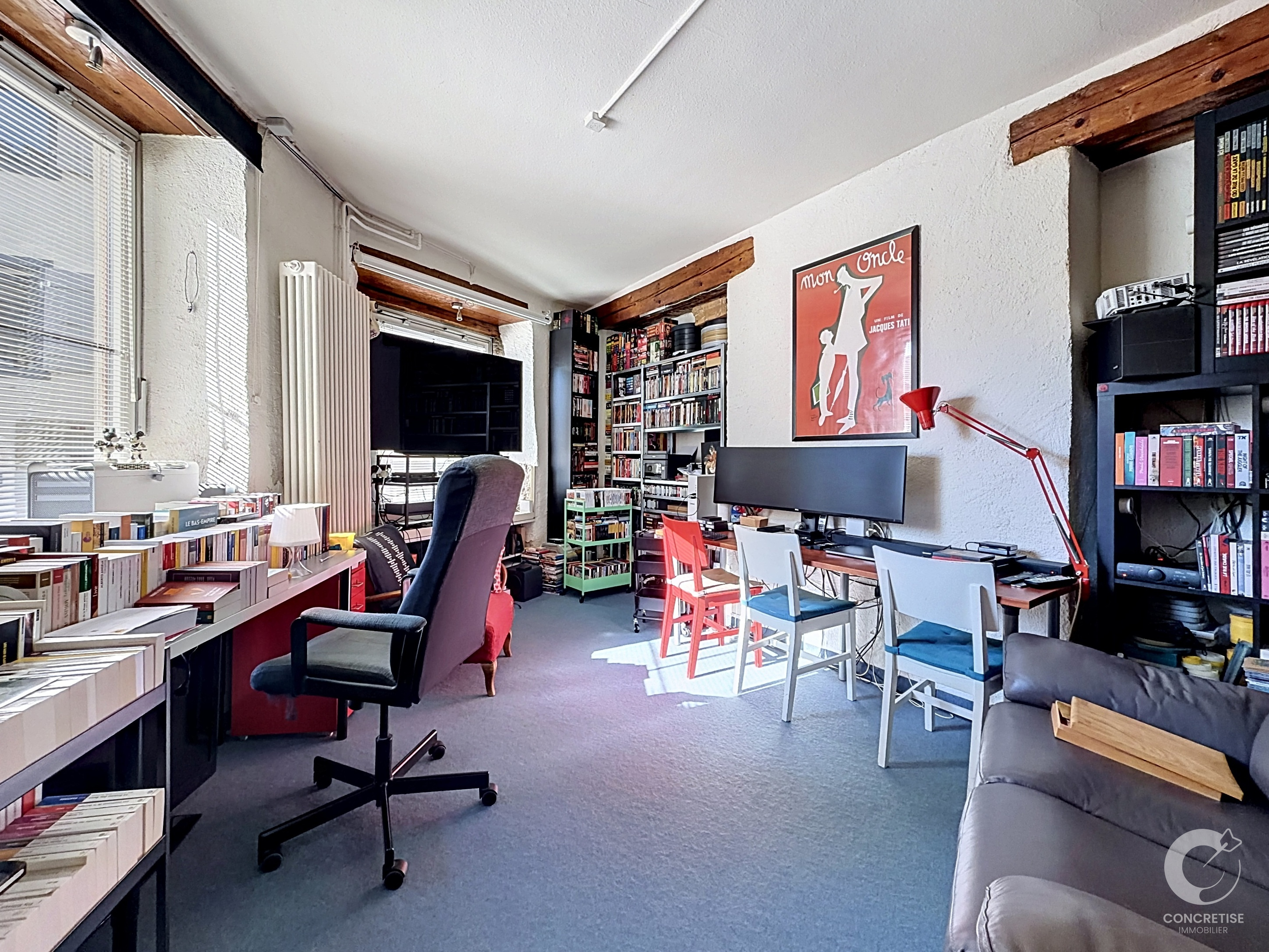 Hell eingerichtetes Arbeitszimmer mit Bücherregalen