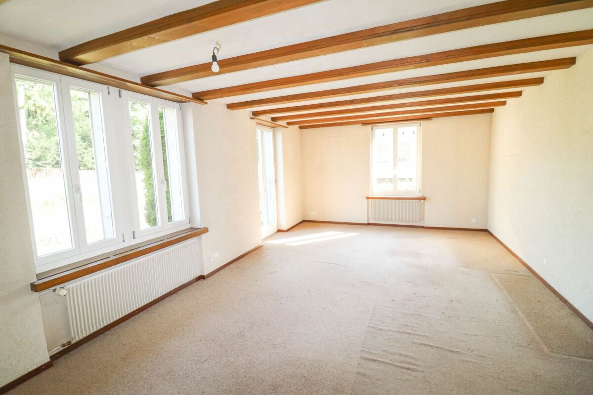 Heller leerer Wohnraum mit Holzbalkendecke
