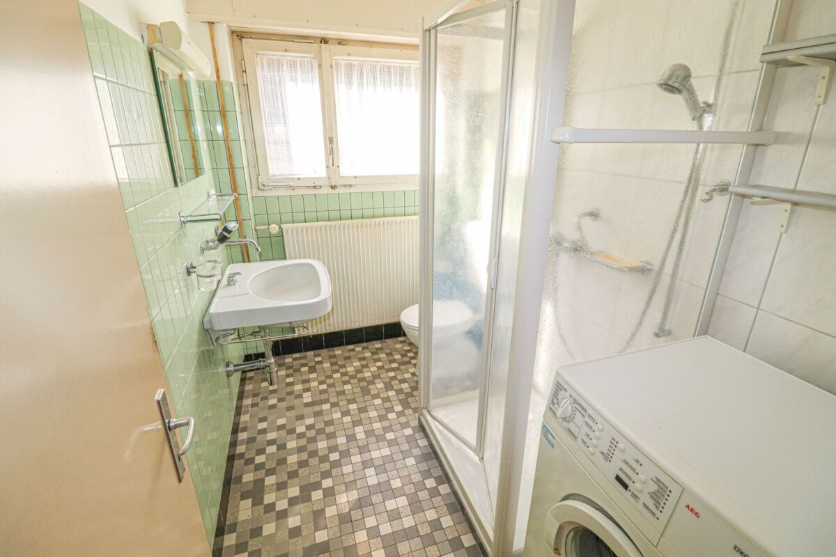 Kleines Badezimmer mit Dusche und Waschmaschine