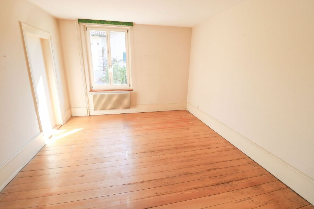 Leerer, heller Raum mit Holzdielen und Fenster