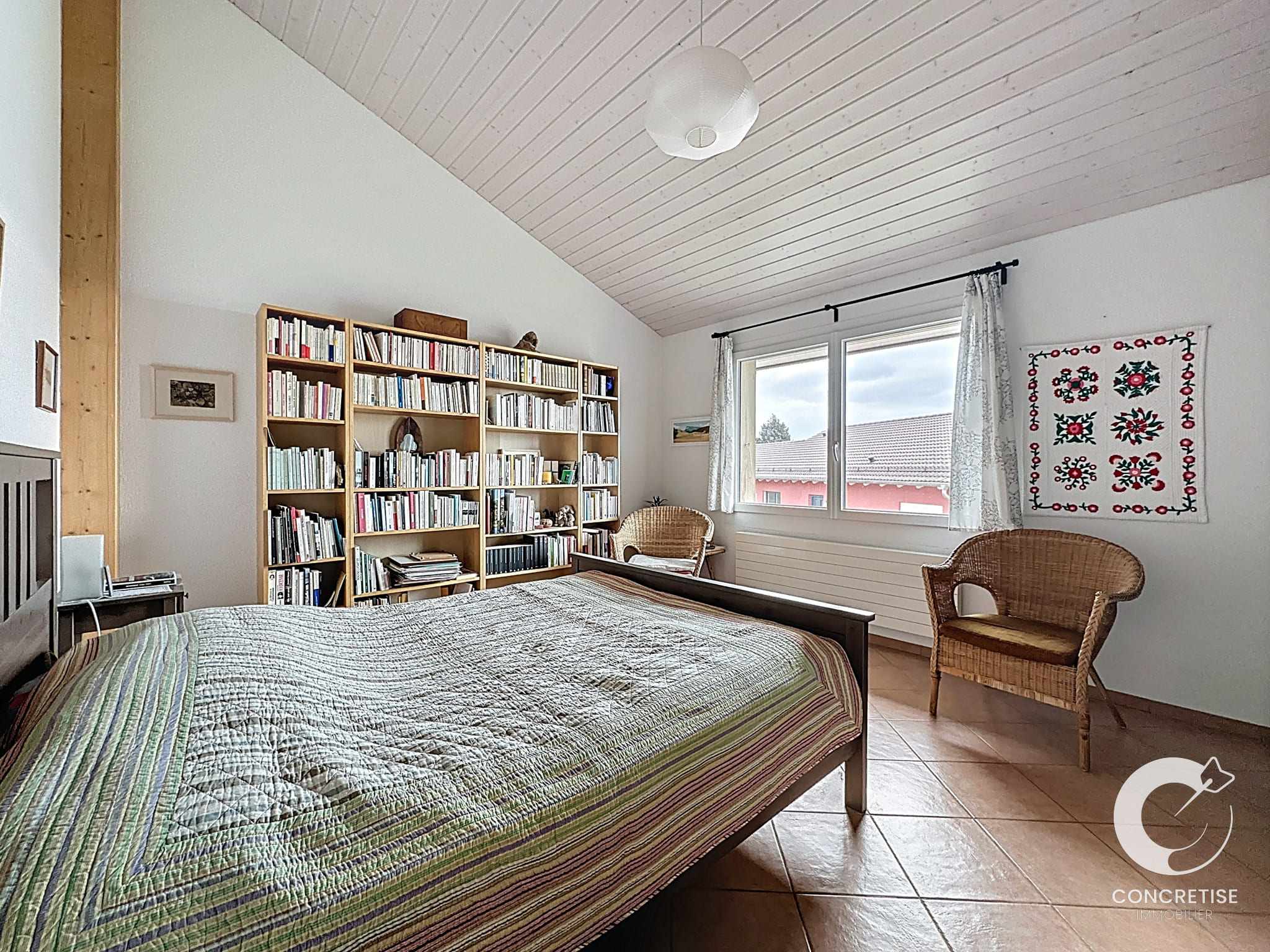 Helles Schlafzimmer mit Dachschräge und Bibliothek