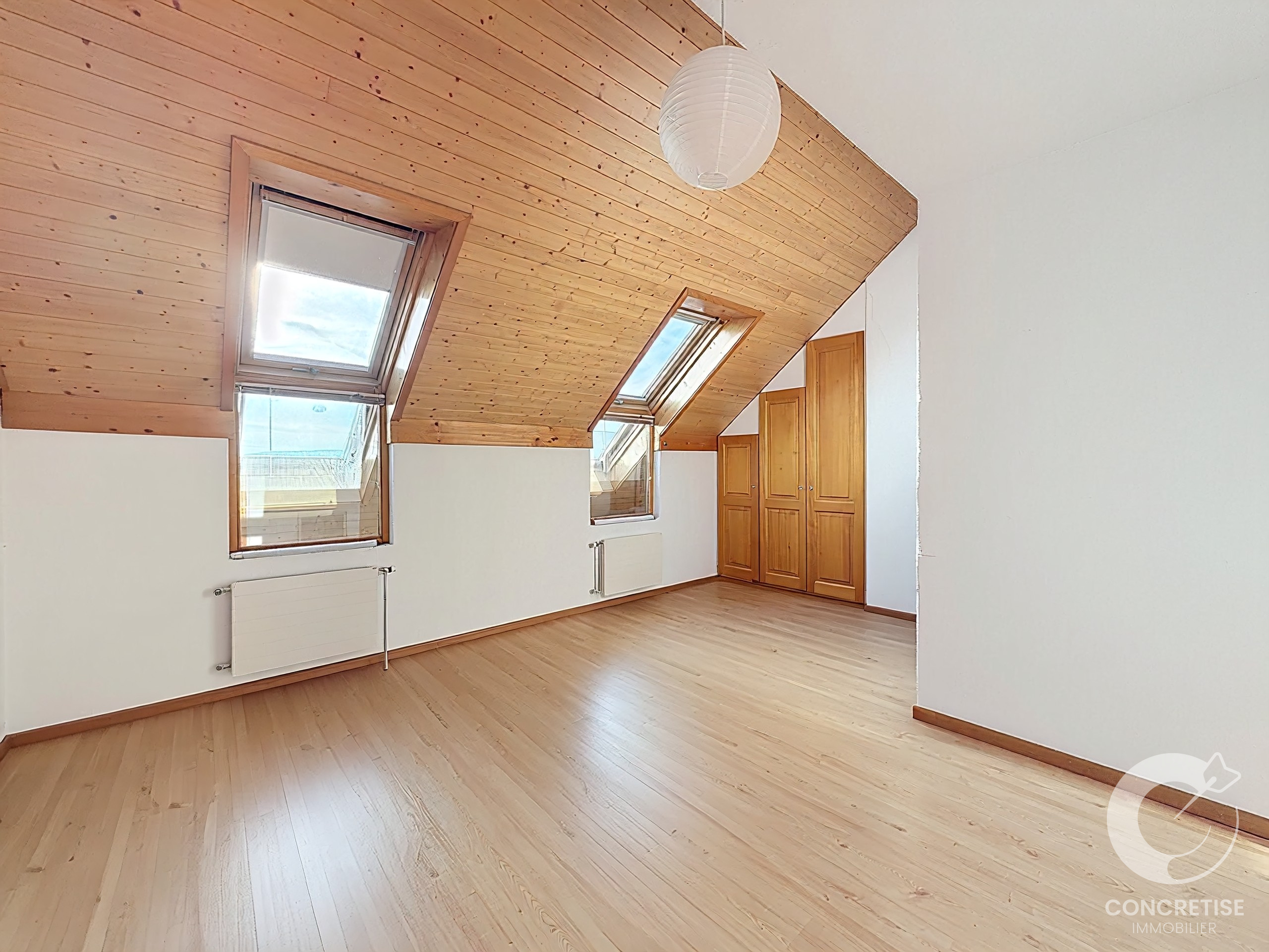 Dachgeschosszimmer mit Dachfenstern und Holzvertäfelung