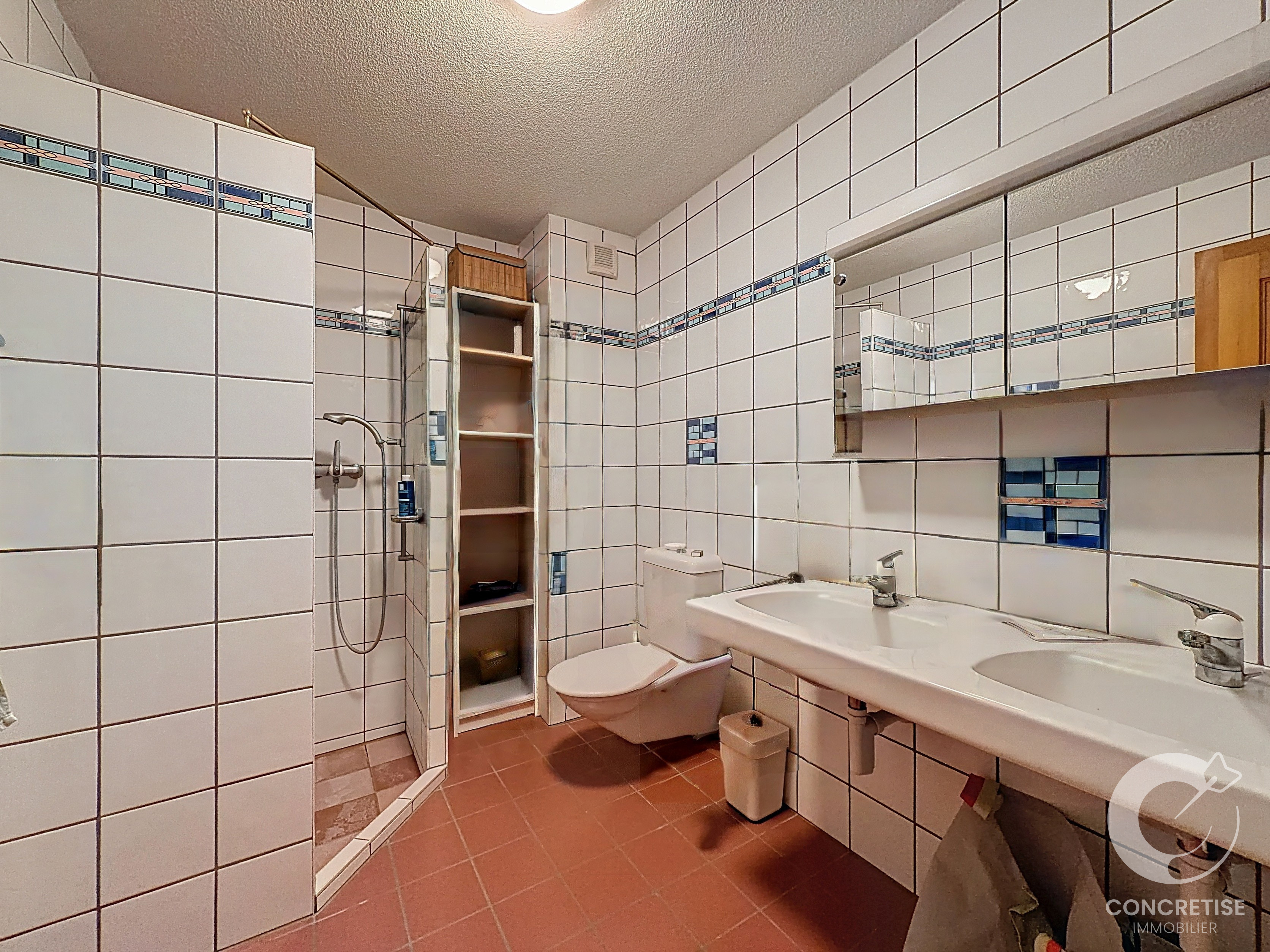 Badezimmer mit Duschbereich und Doppelwaschtisch