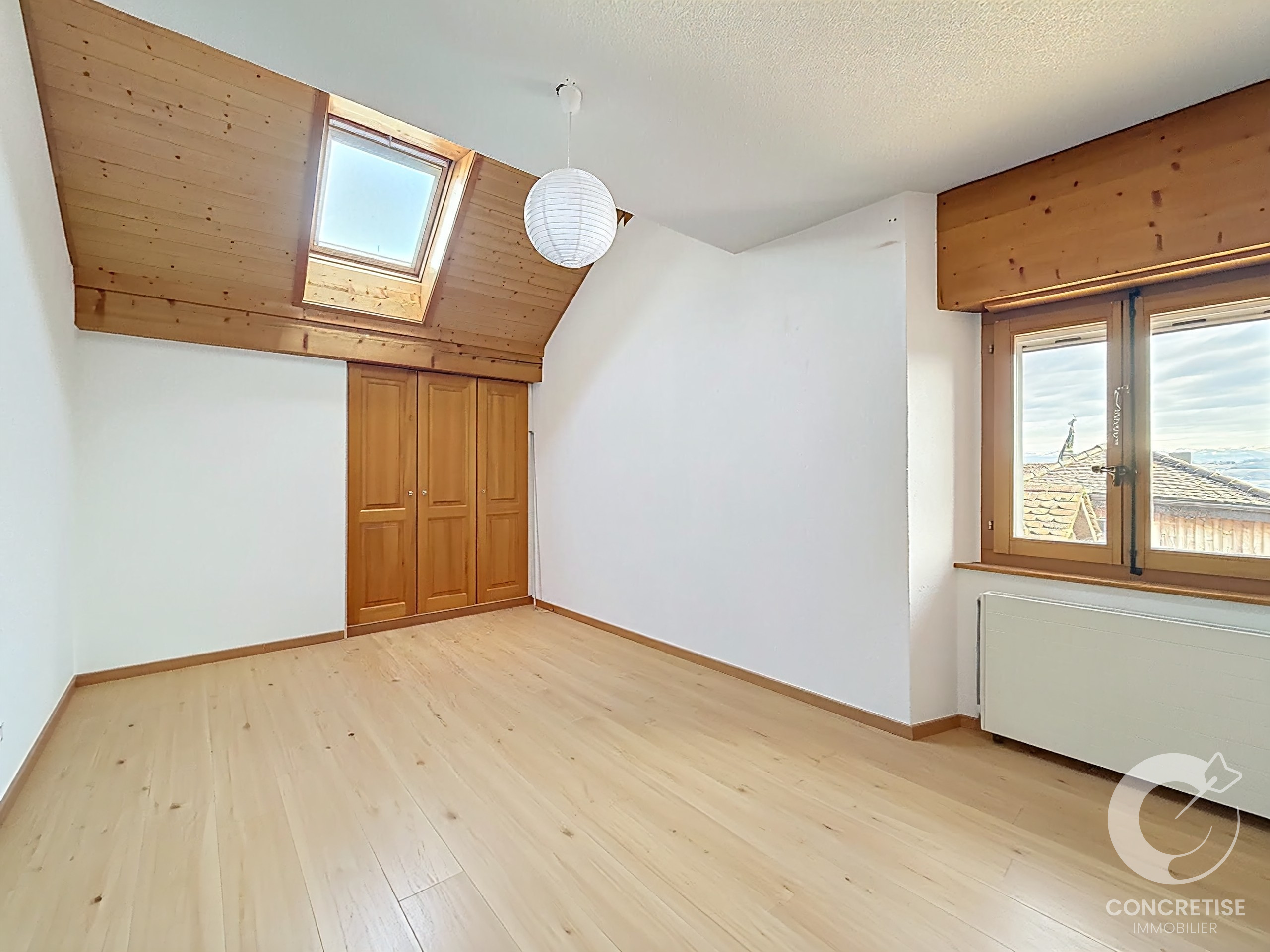 Helles Dachzimmer mit Holzdecke und Dachfenster