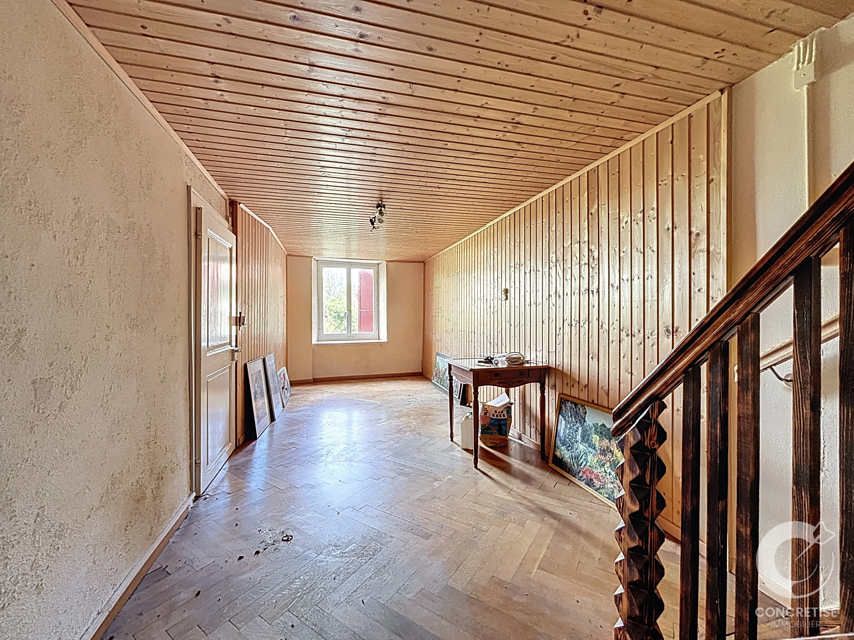 Langer Flur mit Holzverkleidung und Treppe