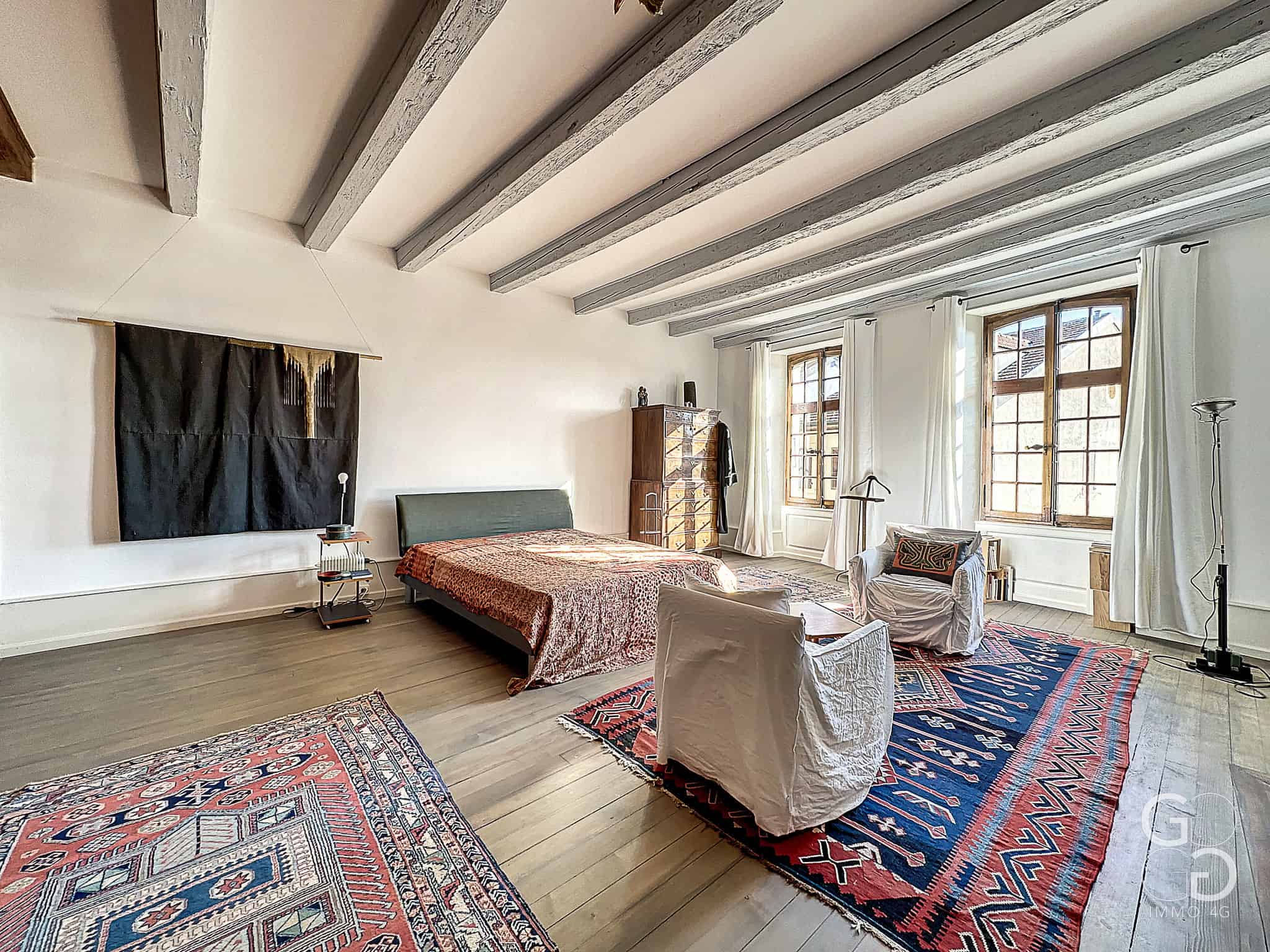 Großes Schlafzimmer mit sichtbaren Holzbalken