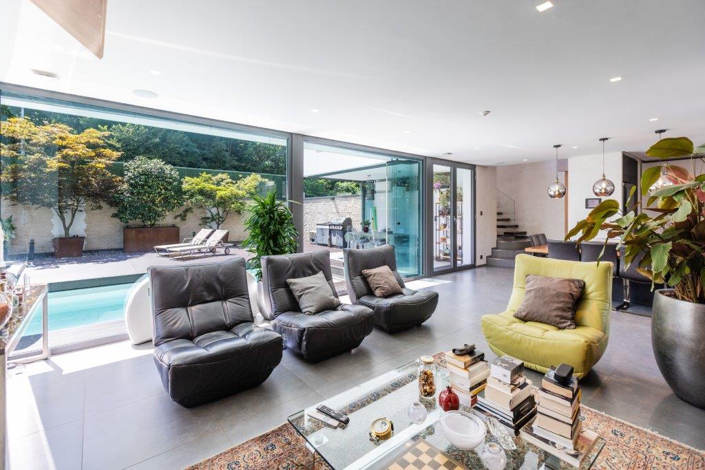 Offener Wohnbereich mit großflächiger Glasfront zum Garten