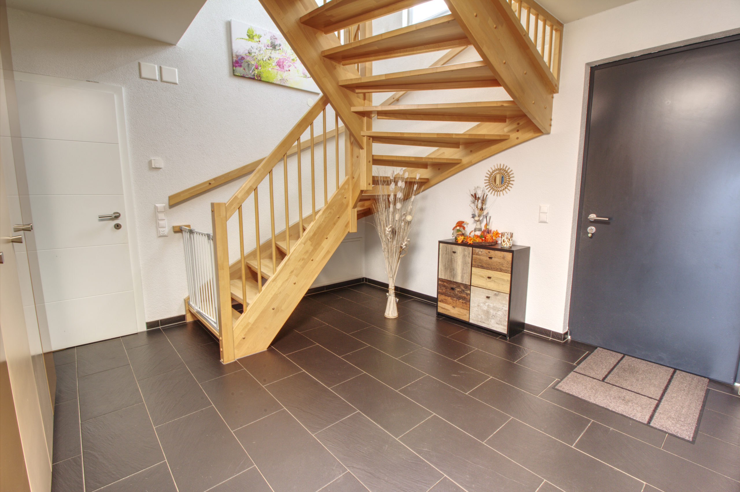 Moderner Eingangsbereich mit Holztreppe