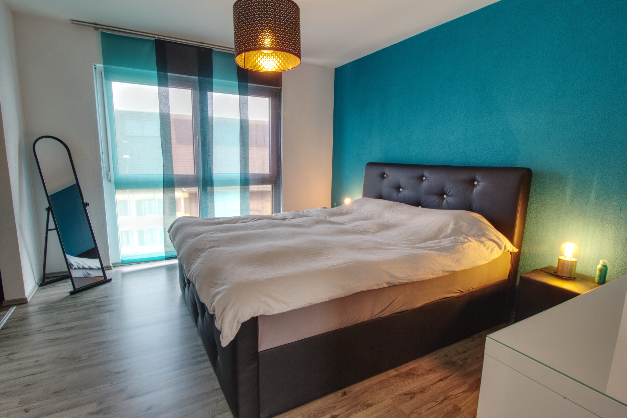 Modernes Schlafzimmer mit türkisfarbener Akzentwand