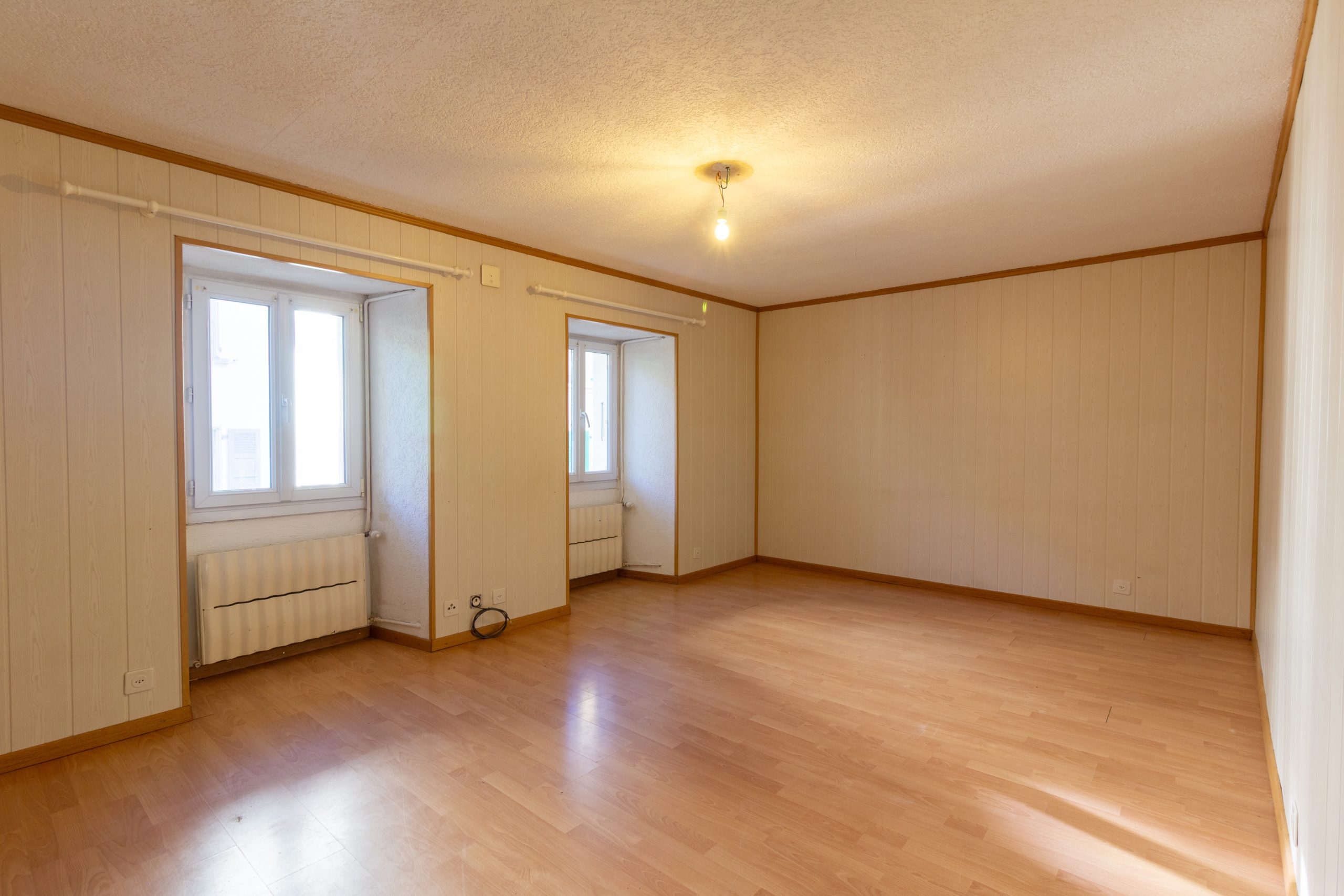 Leeres Zimmer mit Laminatboden und Fenstern