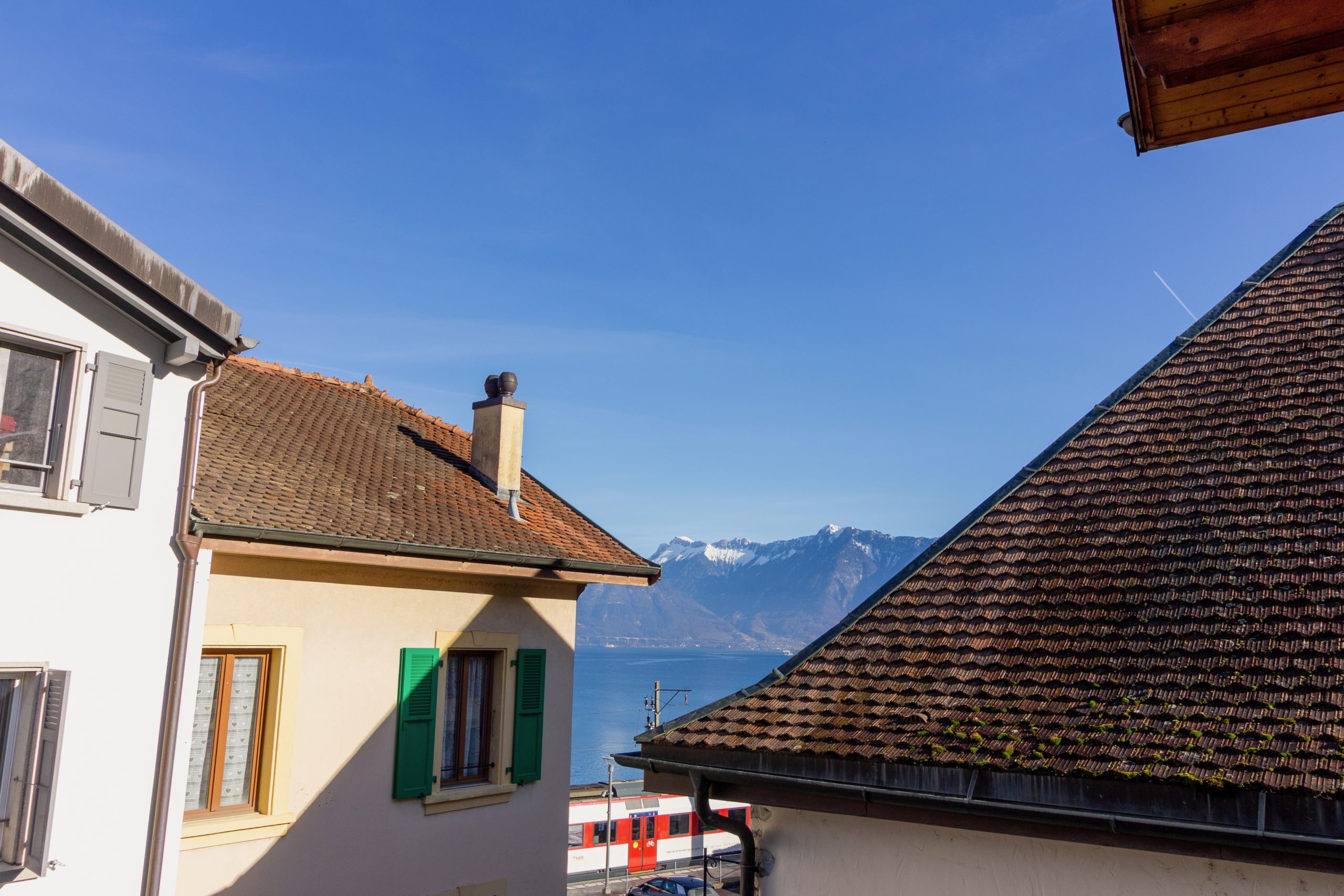Blick auf Dächer, See und Berge