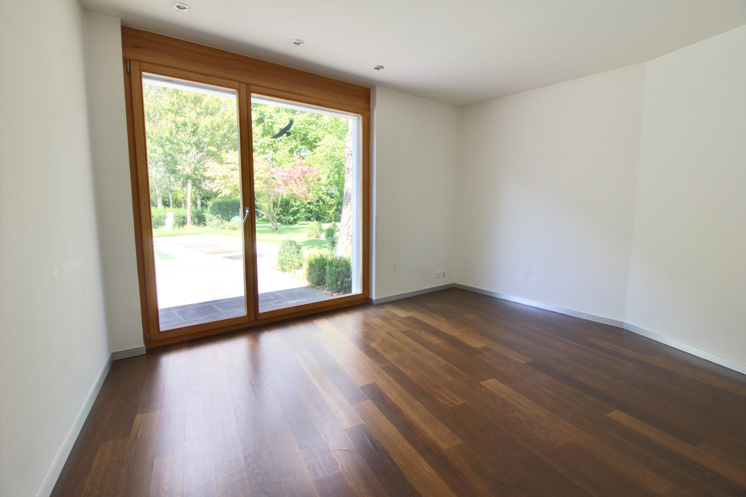 Leerer, heller Raum mit großem Holzfenster