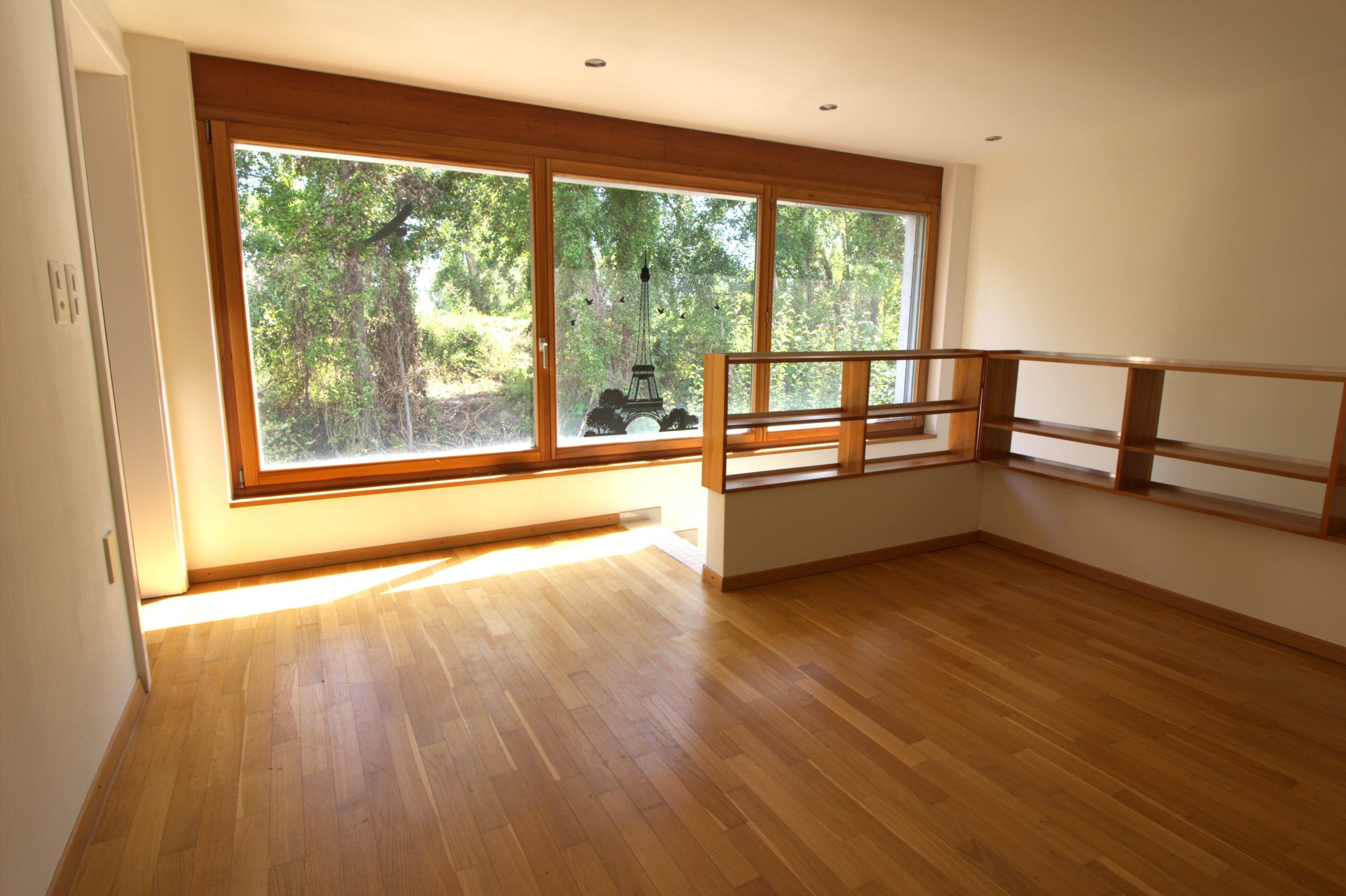 Heller Raum mit großem Panoramafenster und Holzfußboden