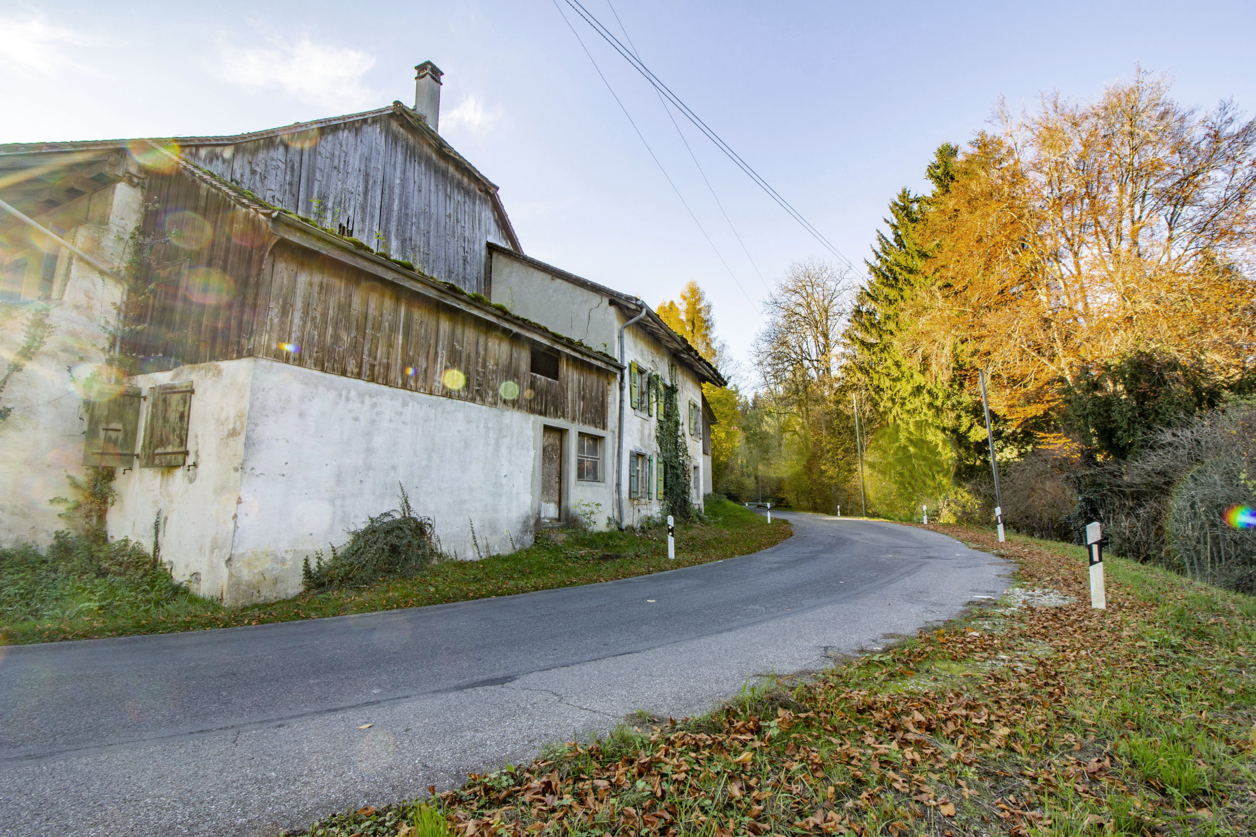 Ländliches Altgebäude an kurviger Straße