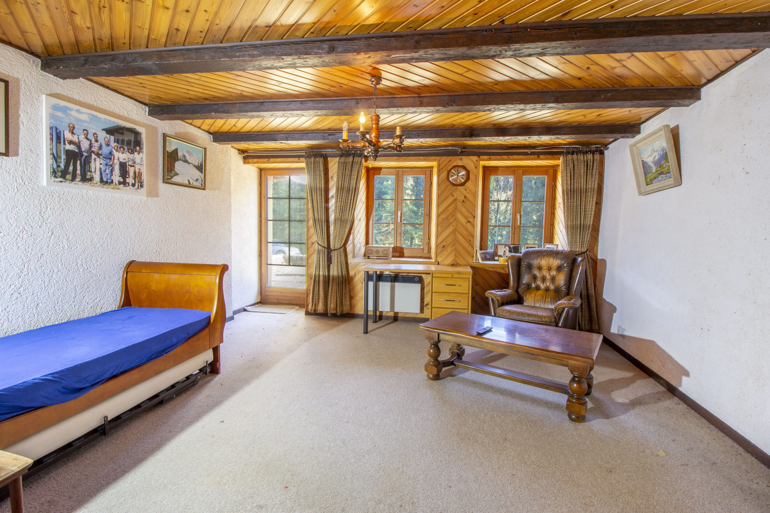 Rustik eingerichtetes Schlafzimmer mit Holzbalkendecke
