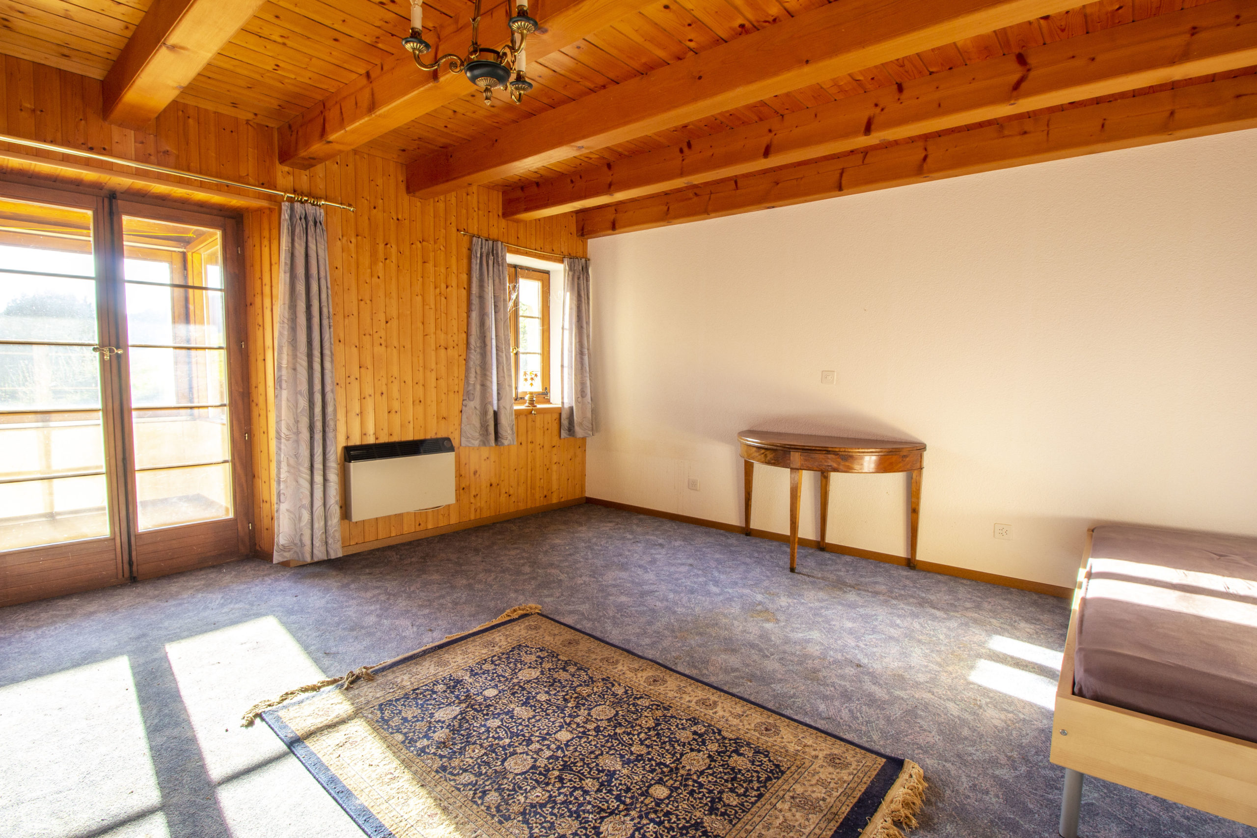Heller, holzvertäfelter Wohnraum mit rustikaler Decke
