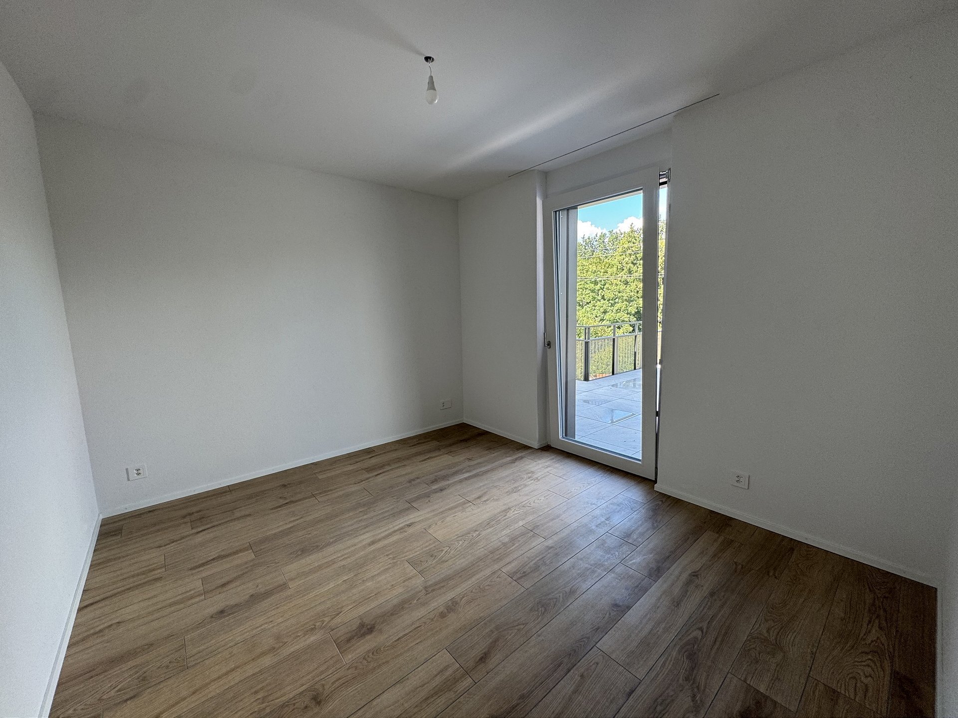 Leerer, modern renovierter Raum mit Balkonzugang