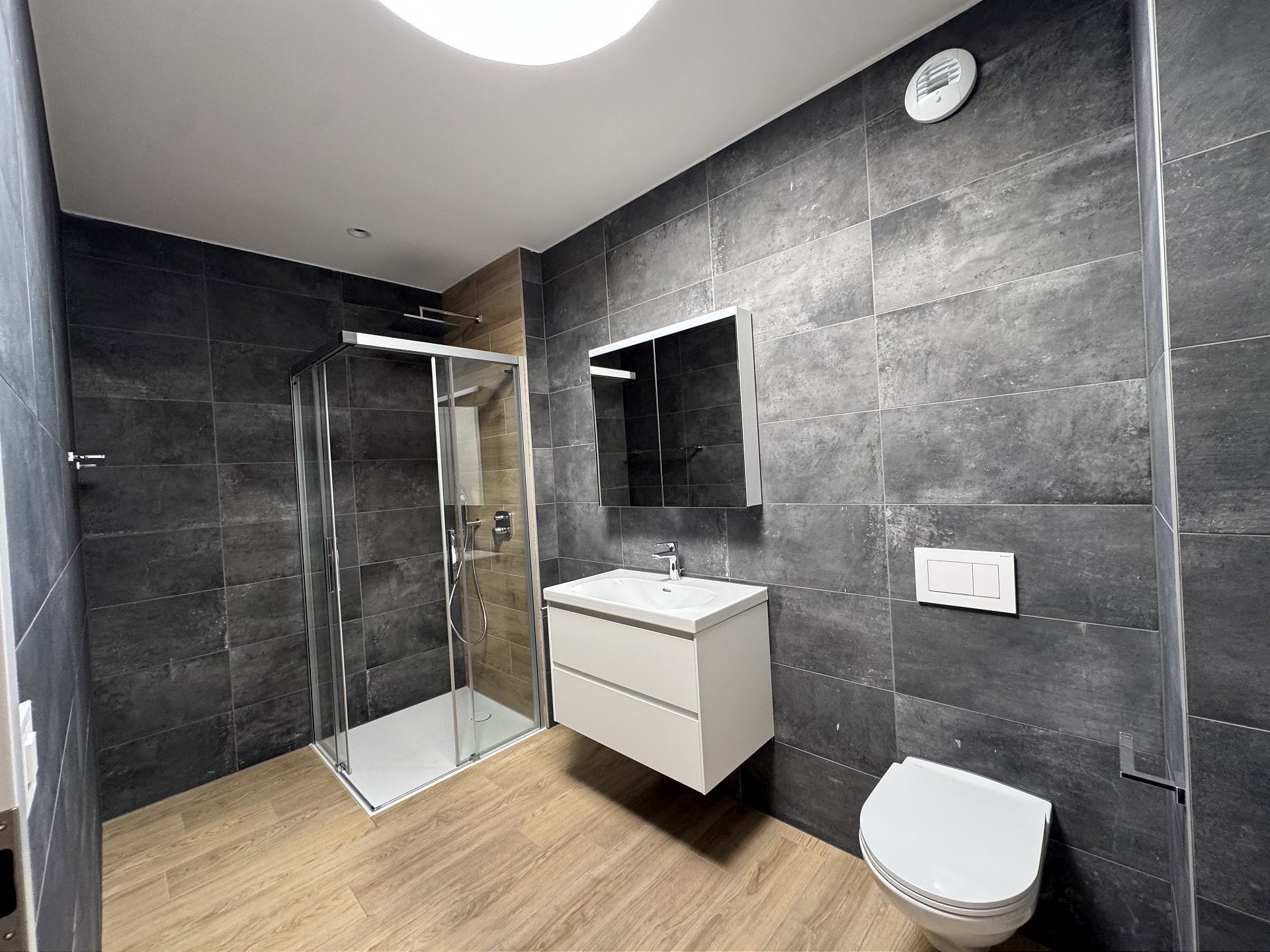 Modernes Badezimmer mit dunkler Fliesenoptik