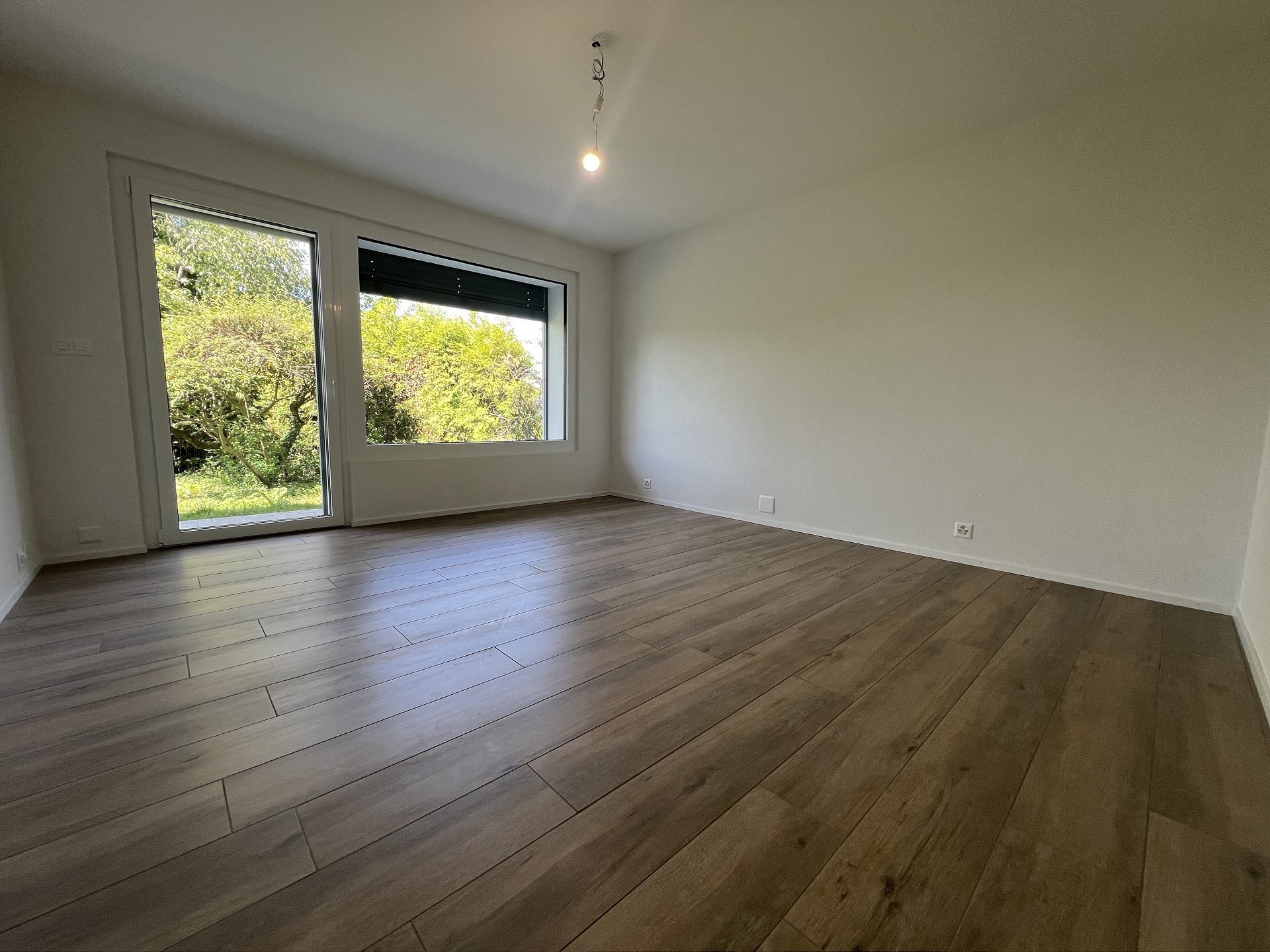 Leerer Wohnraum mit großen Fenstern
