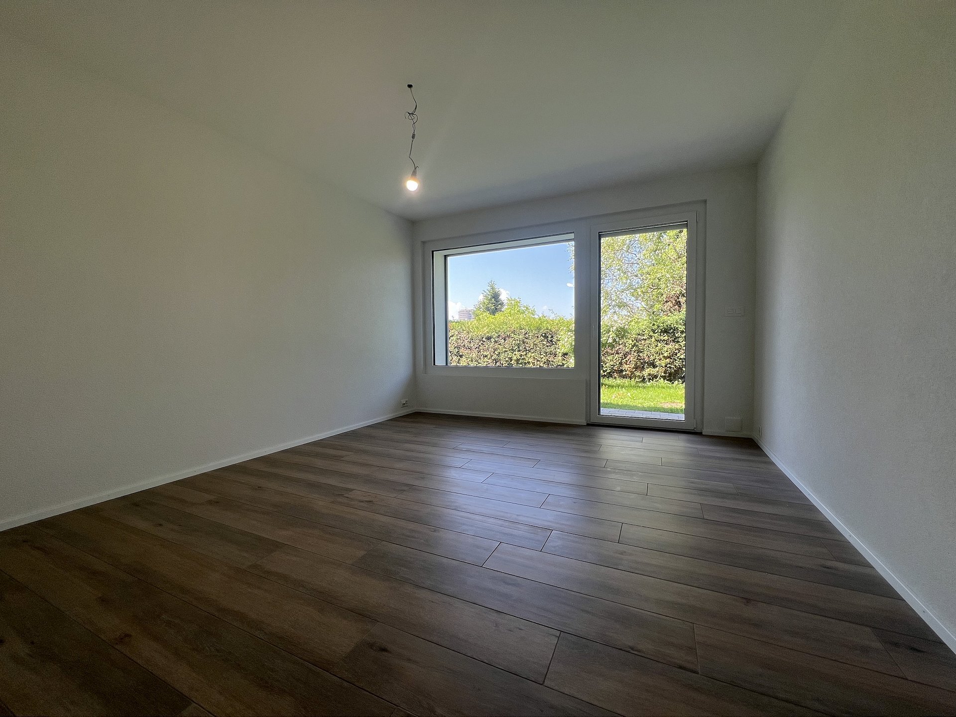 Leerer, heller Wohnraum mit Gartenblick
