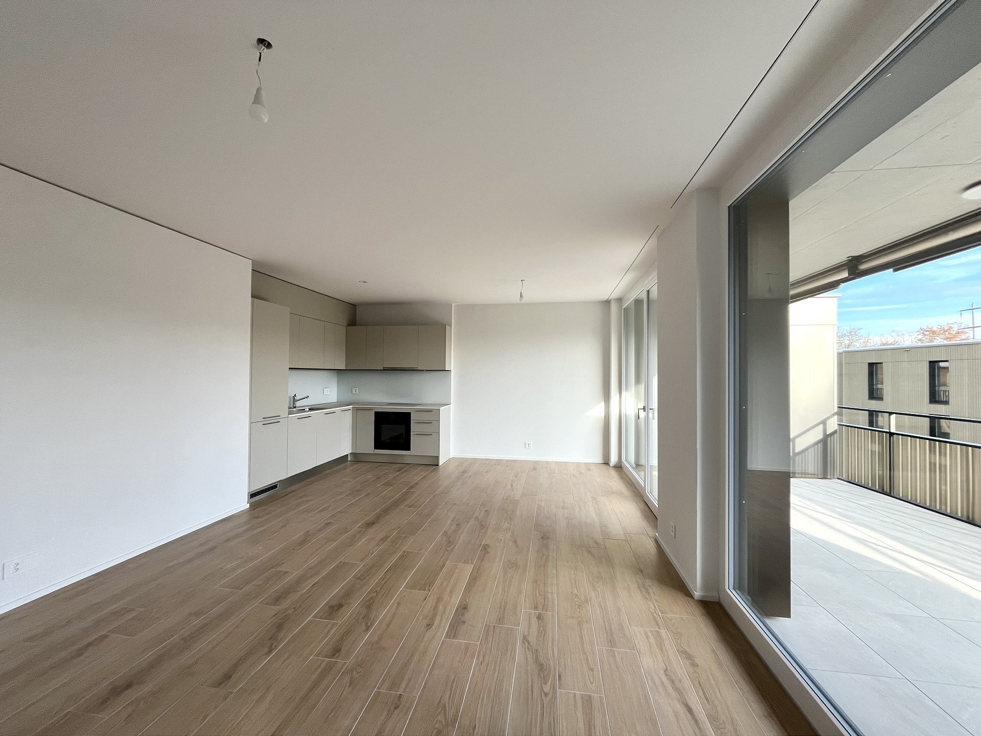 Offener Wohnbereich mit Küche und Balkon