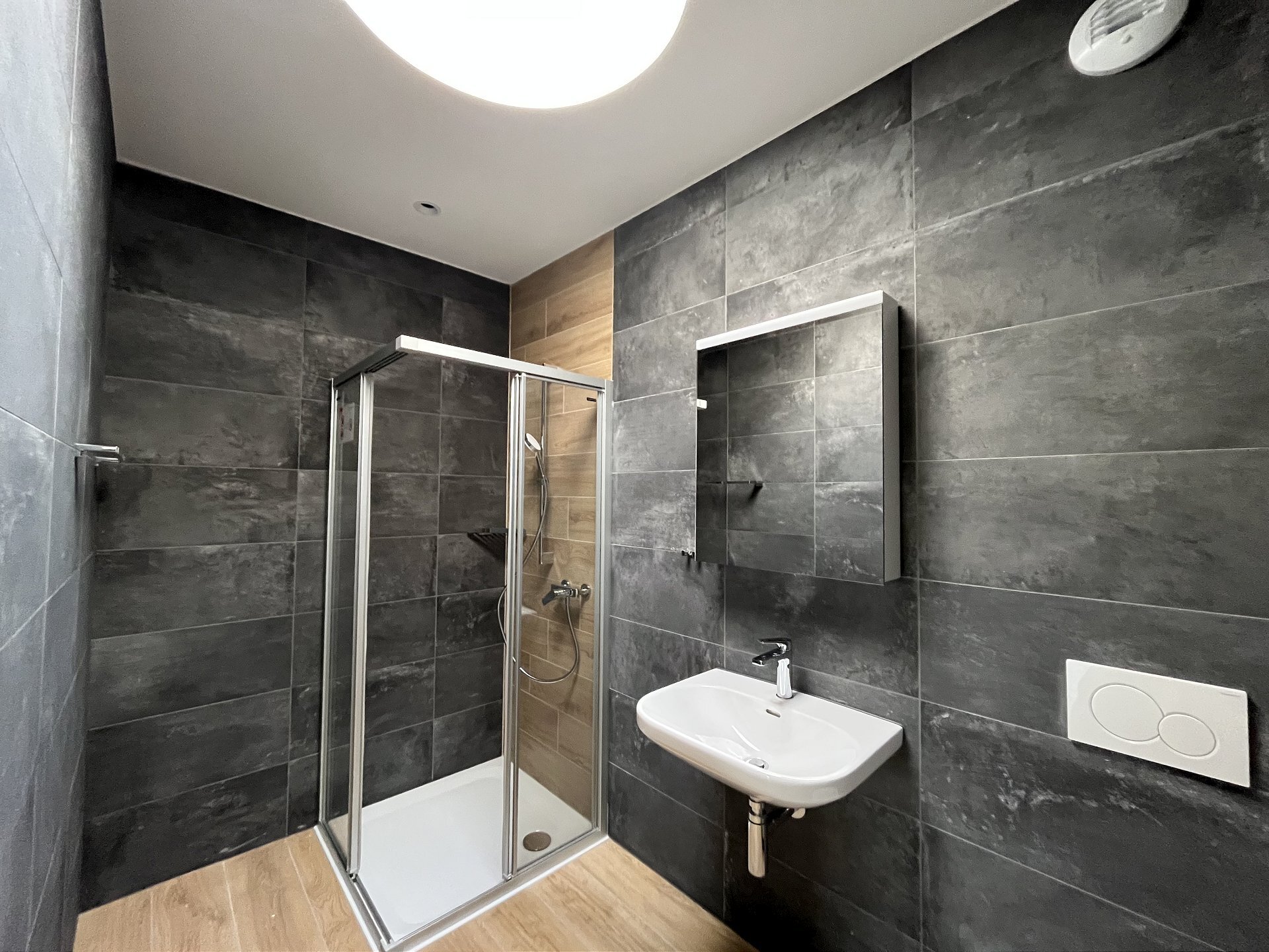 Modernes Badezimmer mit Dusche und Wandwaschbecken