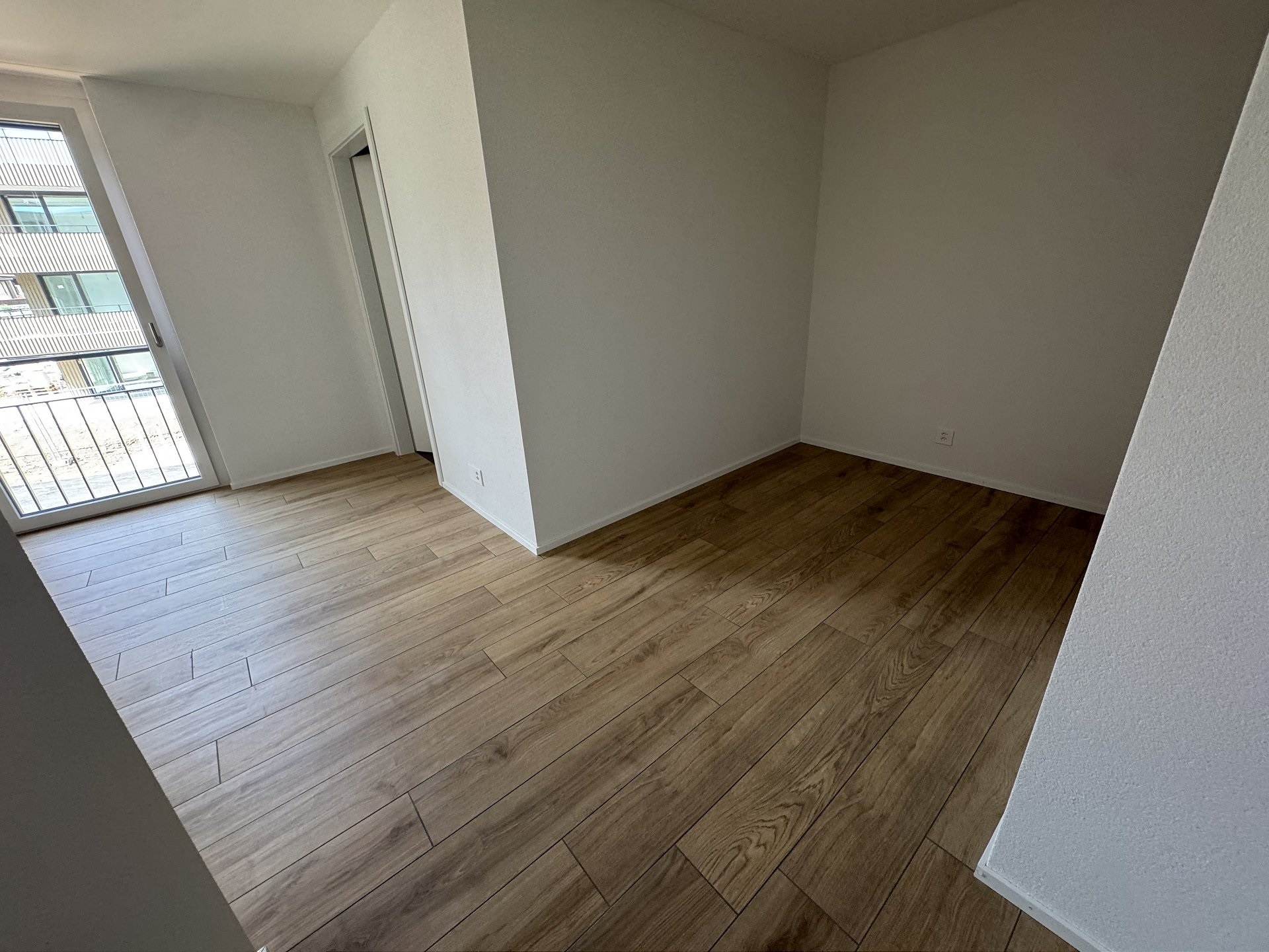 Leerer, heller Raum mit Holzboden